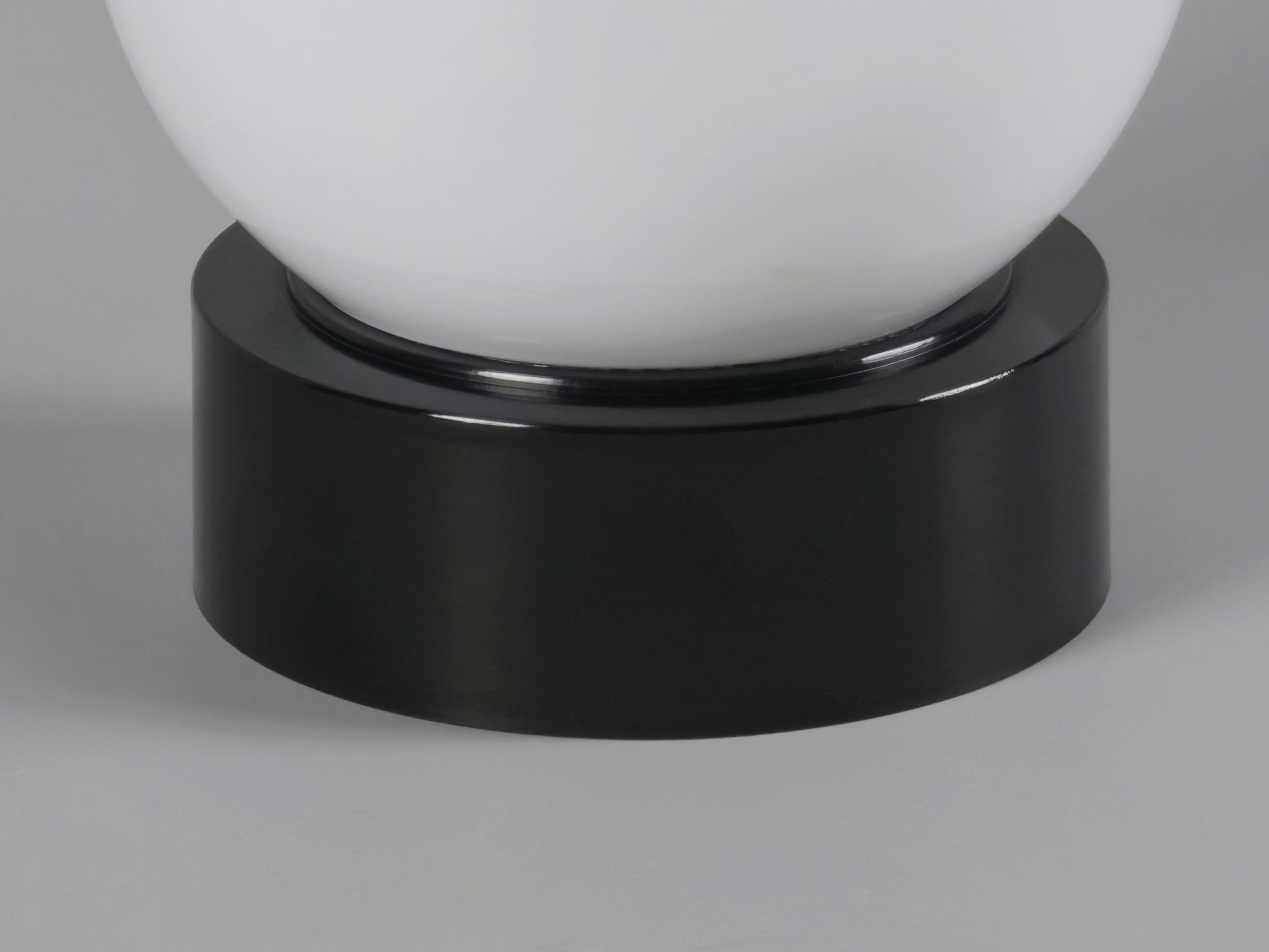 1960s vintage MCM globe glass light fixture by Corodex Holland, macro shot of the black bakelite base showing the clean and smooth texture.