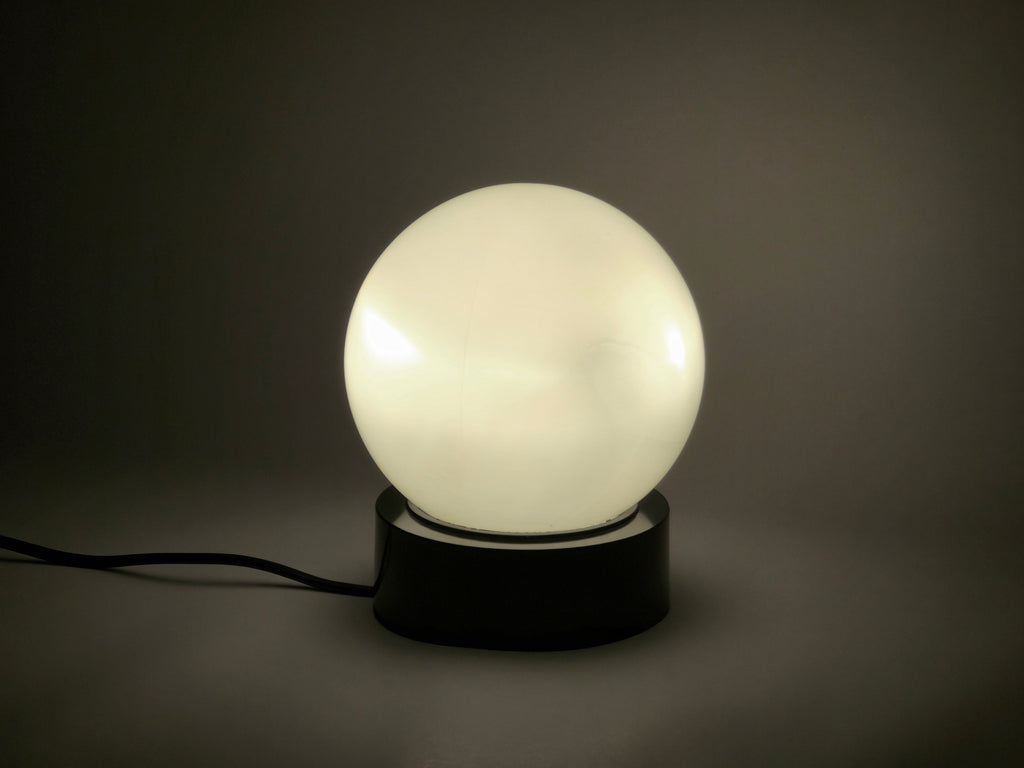 1960s vintage MCM globe glass light fixture by Corodex Holland, bird's eye view, the lamp is laid on a neutral table.