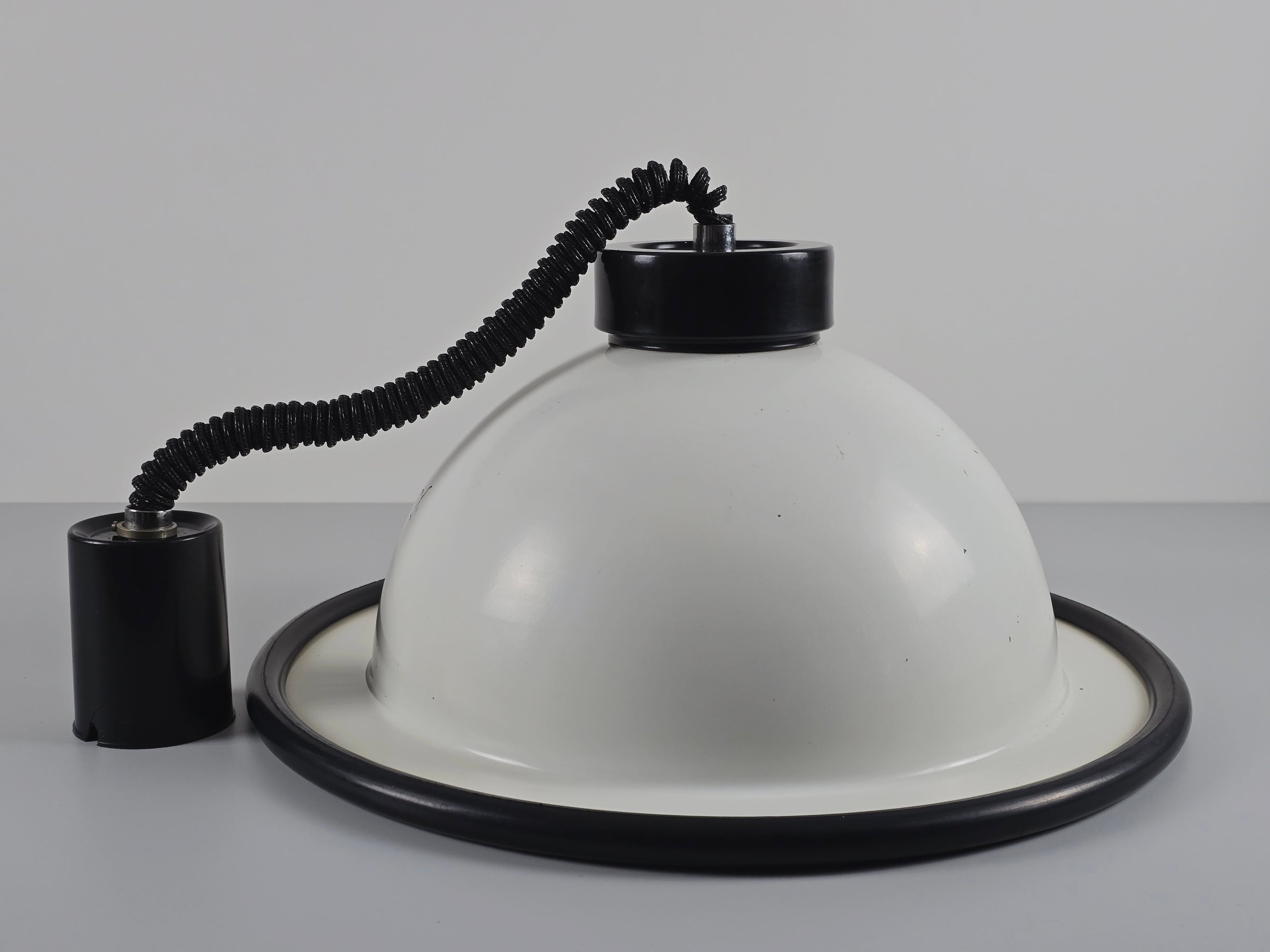 The vintage 1960s MCM Martinelli Luce rise & fall pendant lamp by Elio Martinelli laid on its side to show the black counterweight and ceiling rose.