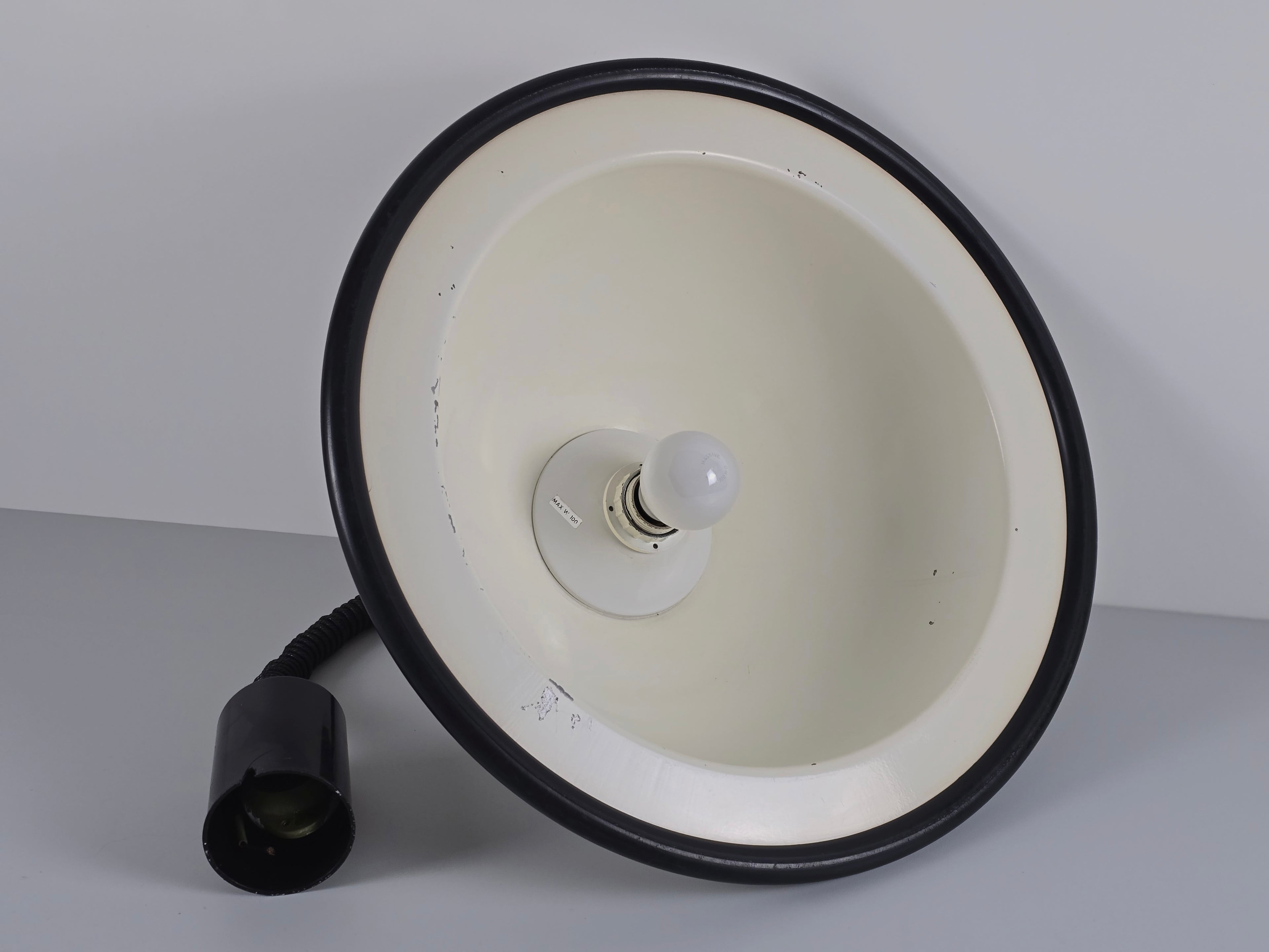 An underside view of the vintage 1960s MCM Martinelli Luce rise & fall pendant lamp by Elio Martinelli revealing the internal light bulb and white interior.