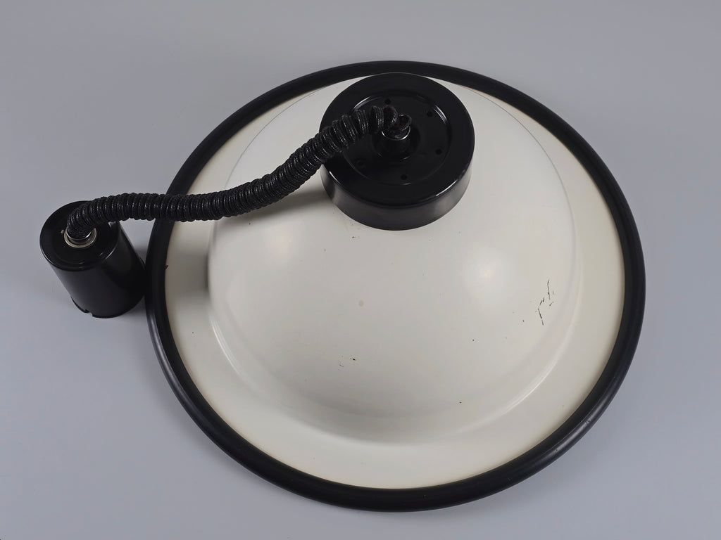 A top-down view of the vintage 1960s MCM Martinelli Luce rise & fall pendant lamp by Elio Martinelli emphasizing the black hardware and coiled cord.