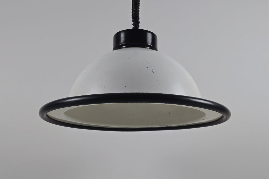 A primary studio shot of the vintage 1960s MCM Martinelli Luce rise & fall pendant lamp by Elio Martinelli, featuring a white domed shade with a black rim.