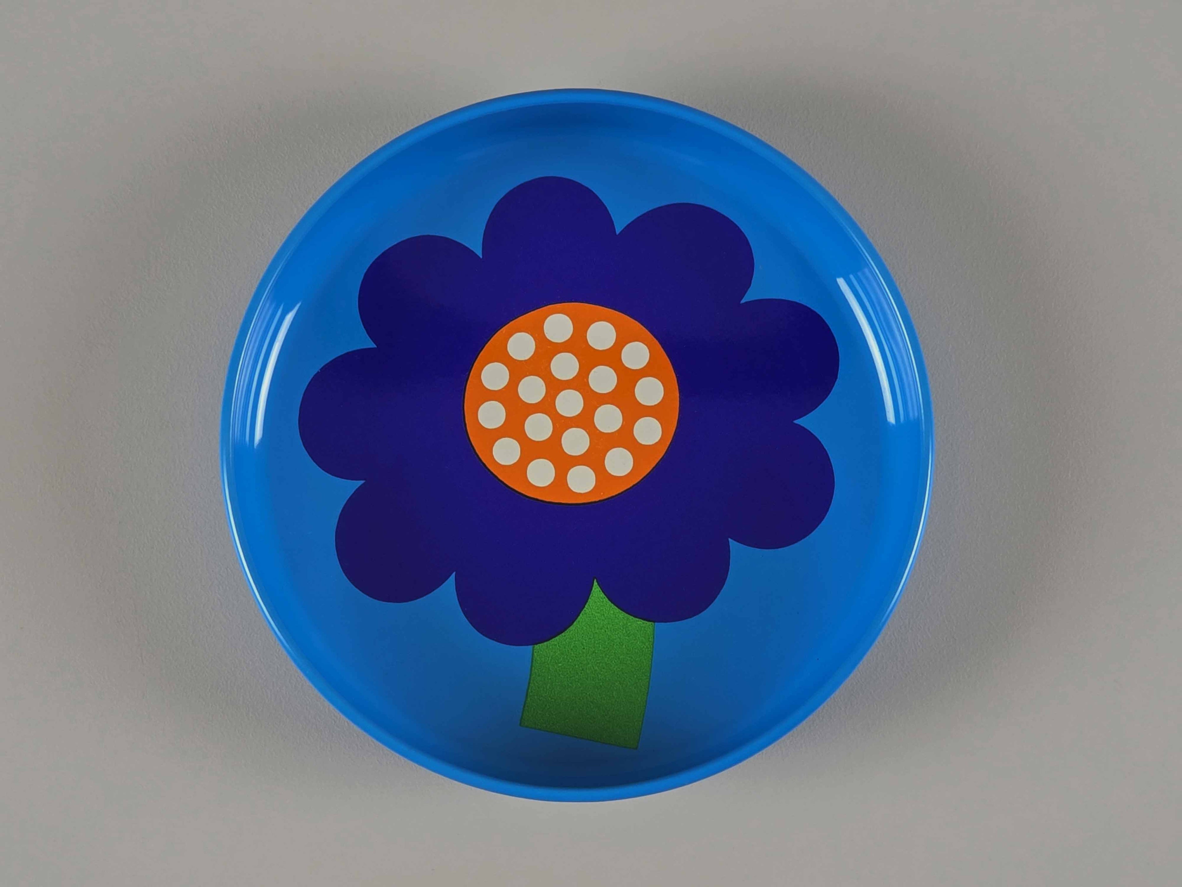 Top view of a vintage 1970s Laurids Lønborg tin tray designed by Al and Lena Eklund, featuring a bold purple flower on a blue background.