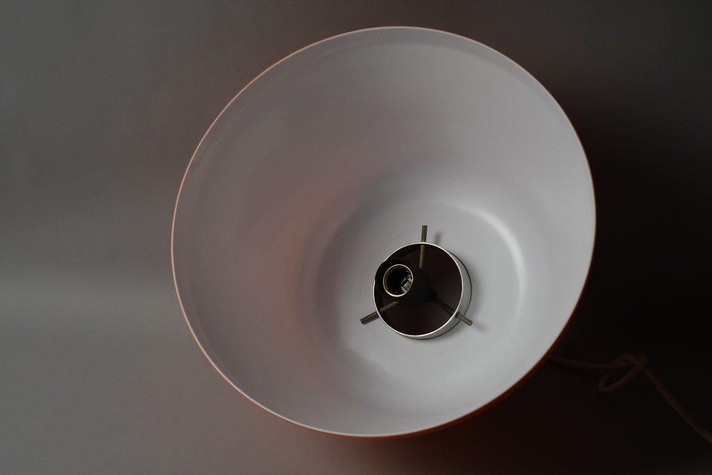 Interior view looking up into a 1970s dual-layer orange acrylic Space Age pendant lamp, showing the smooth white bonded interior surface and central E27 lamp fitting.