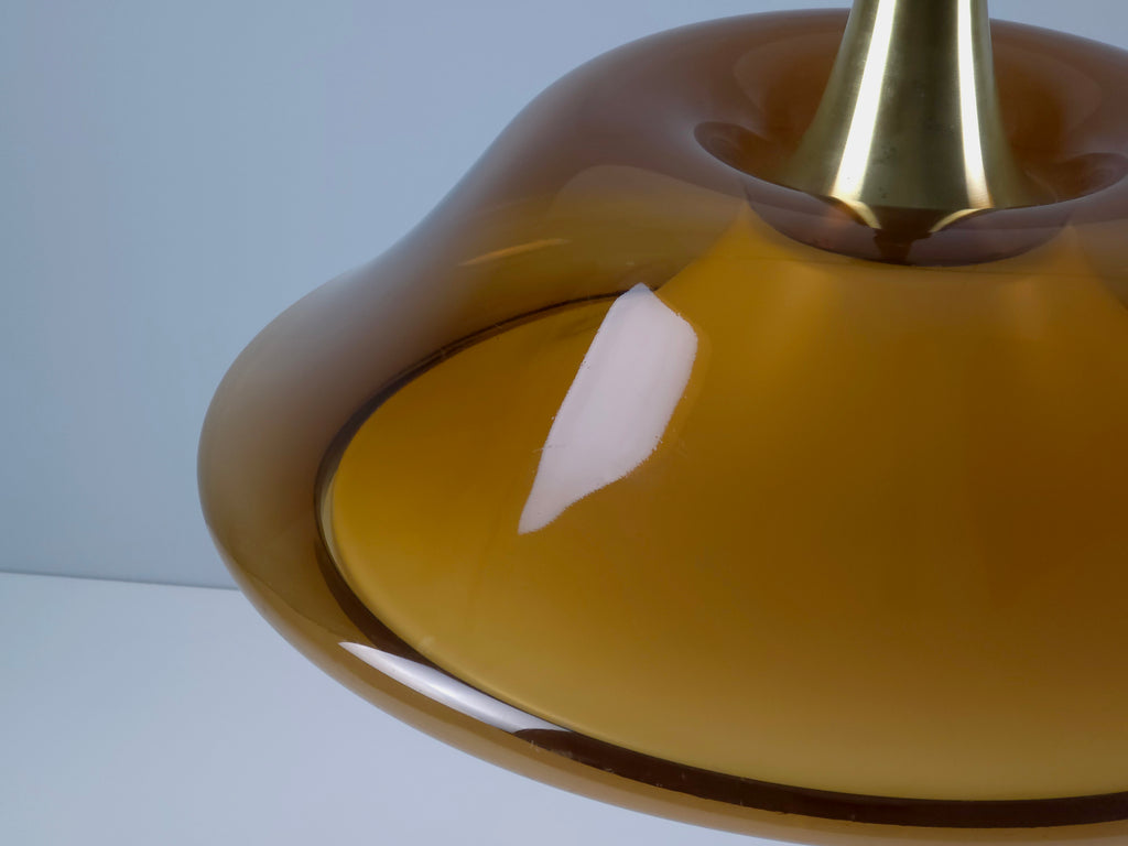 Angle view of the top of the amber shade, showing the trumpet-shaped brass attachment point for the pull-down cable.