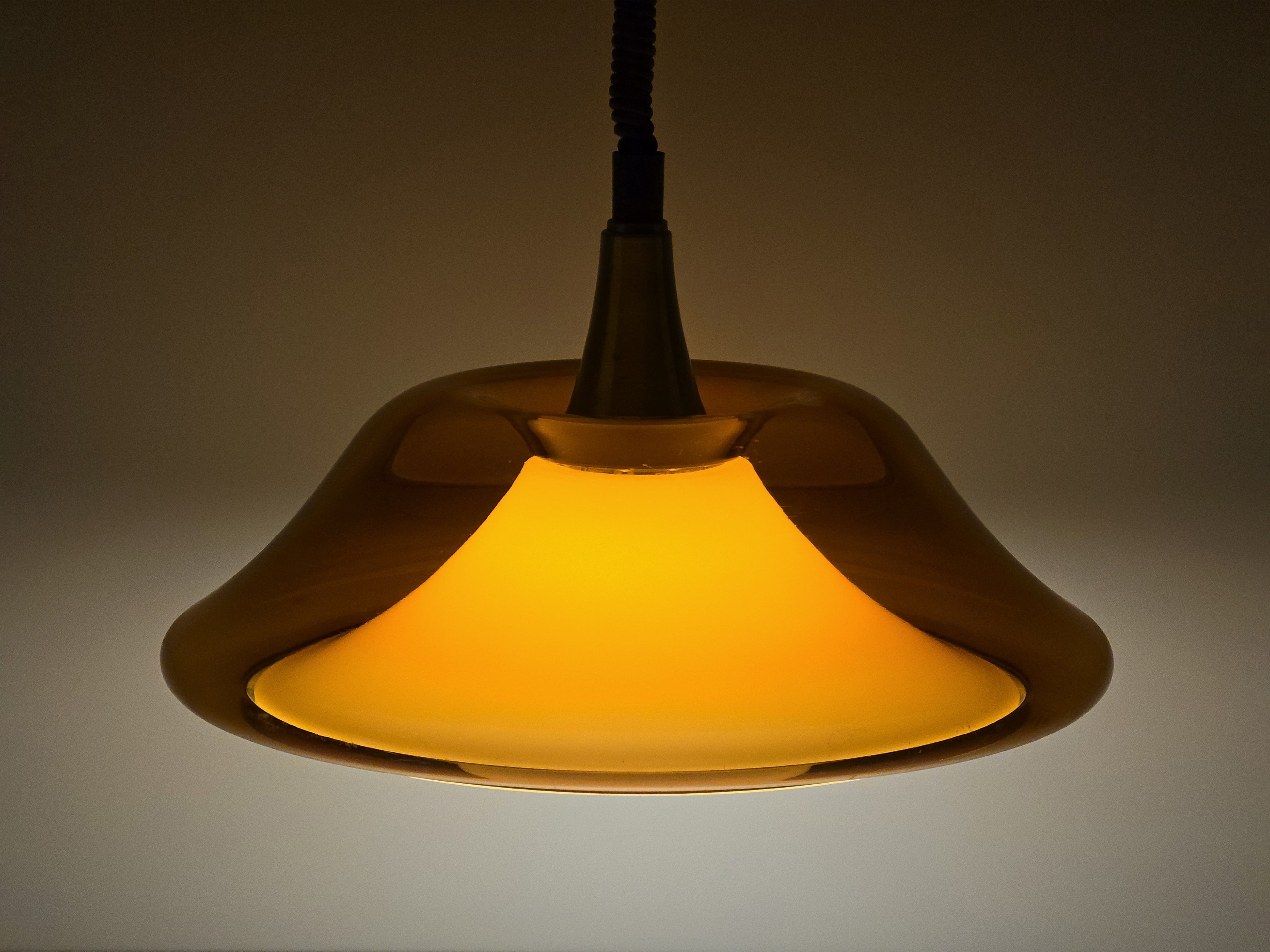 Atmospheric shot of the amber lamp lit in a dim setting, demonstrating its warm ambient light quality.