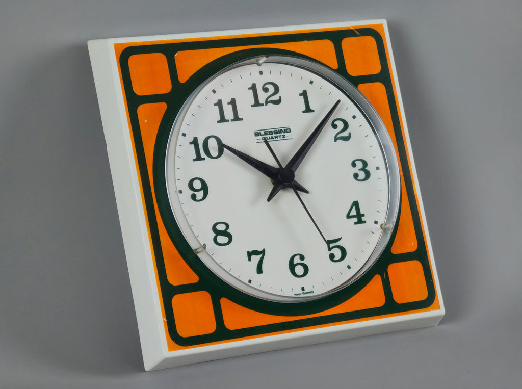 1970s Space-Age Design Blessing orange plastic wall clock, angled view showing the face and depth of clock.