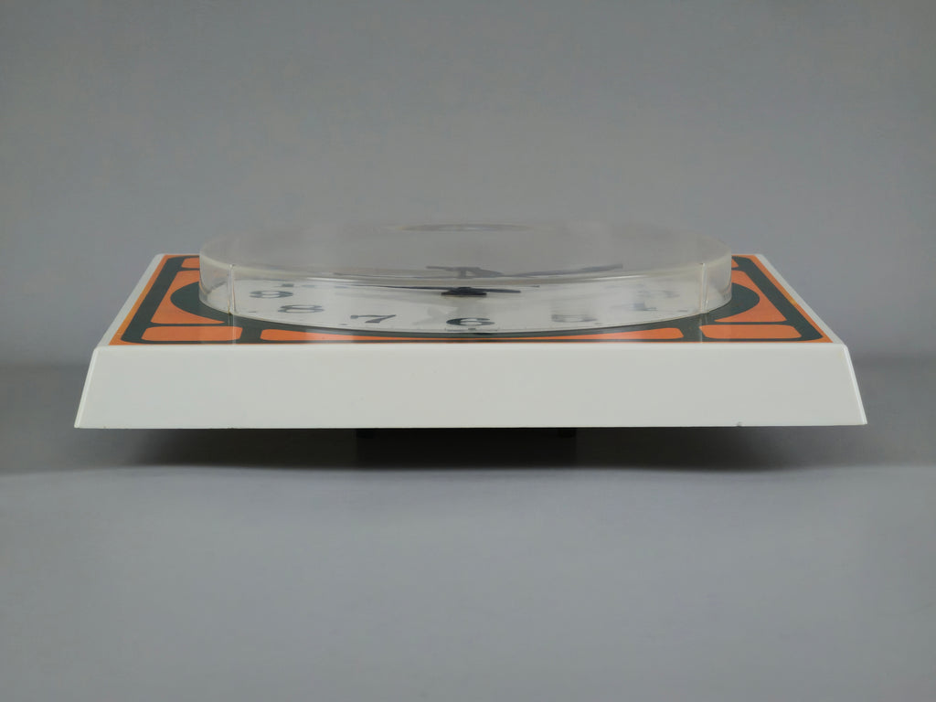 1970s Space-Age Design Blessing orange plastic wall clock, profile view showing the sides and thickness of the clock.