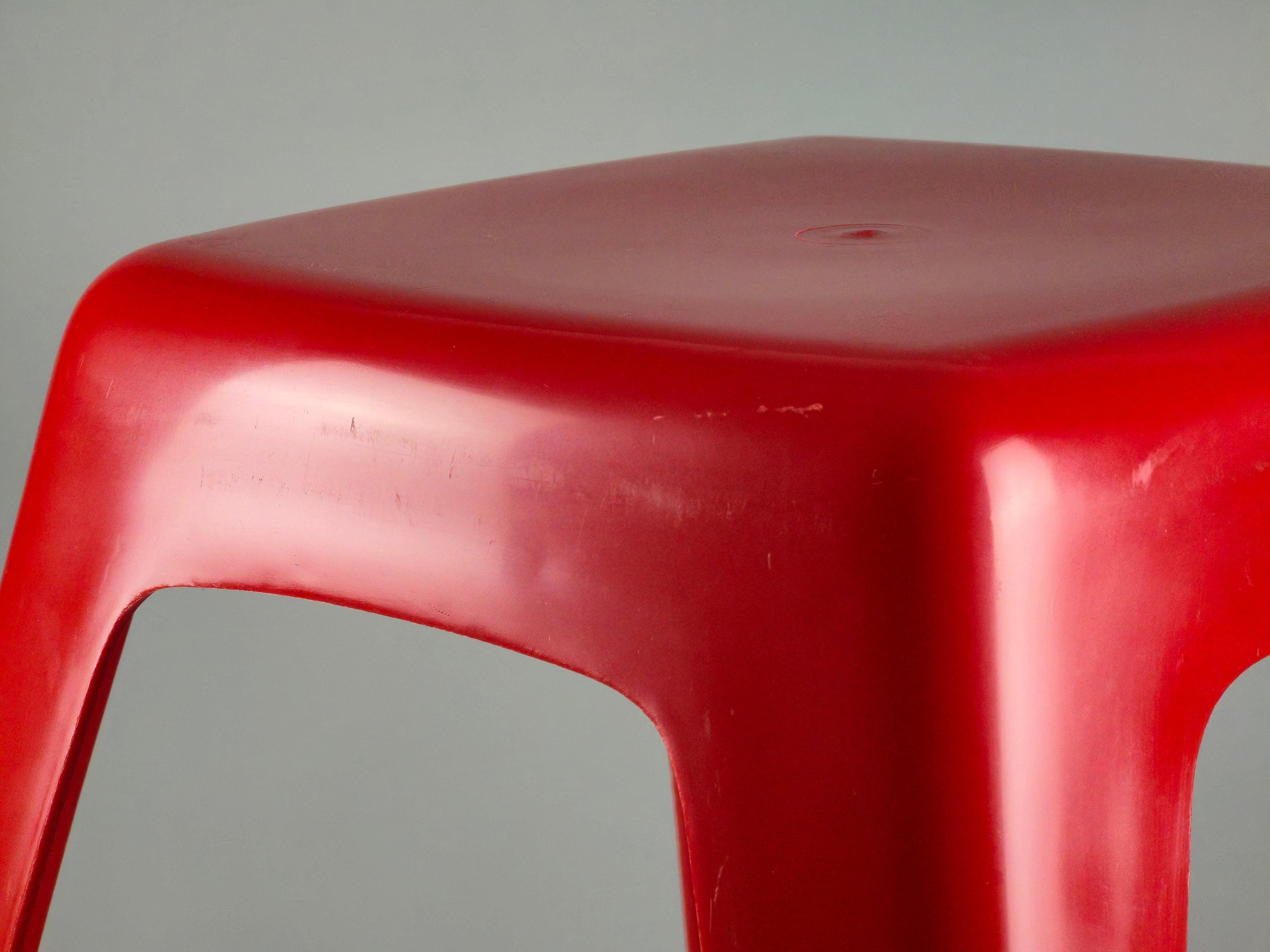 Macro shot of the red plastic texture. The image shows the high-quality molded construction and a close-up of the authentic vintage patina and polished finish.