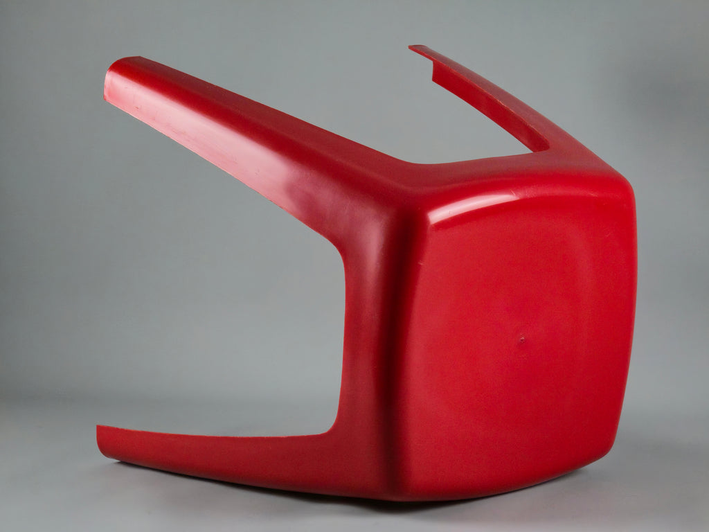 Laid down image of the stool showing the top and the beautiful red plastic construction details.