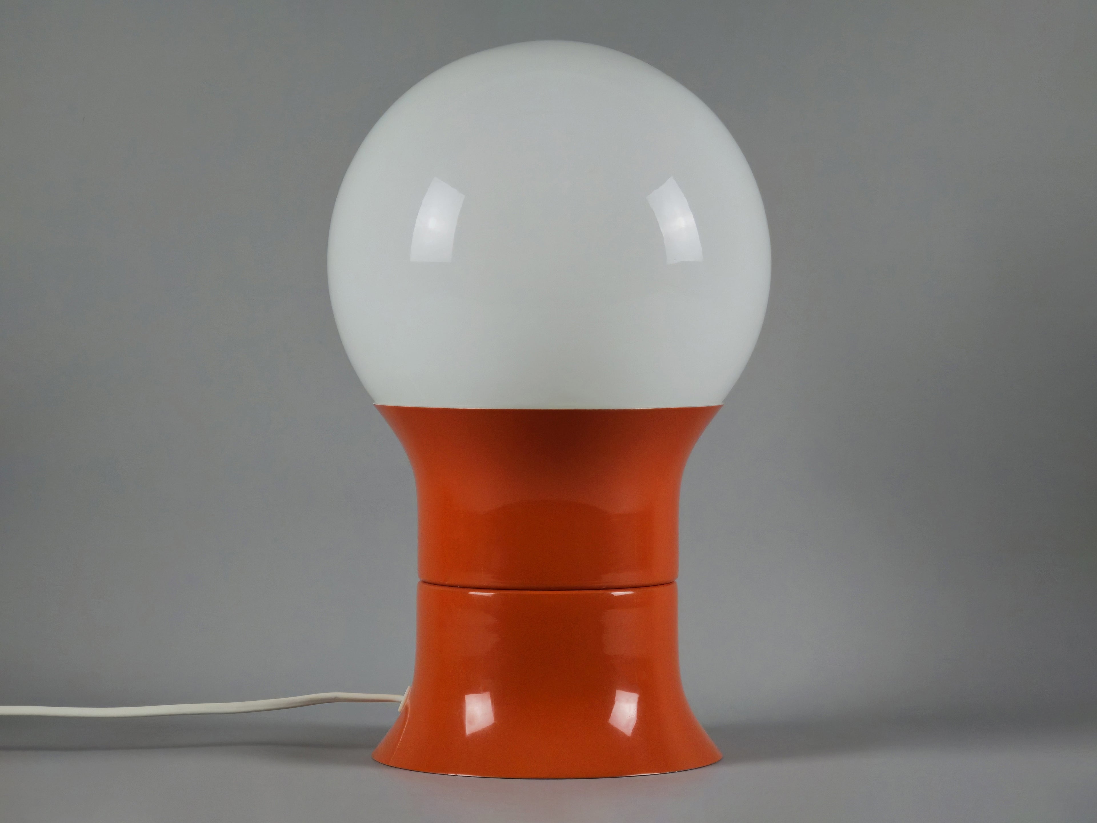 1971 Space age design 'HEMI Klot 2' table lamp by Lennart Centervall, with opaline glass ball shade and orange lacquered base, front view.