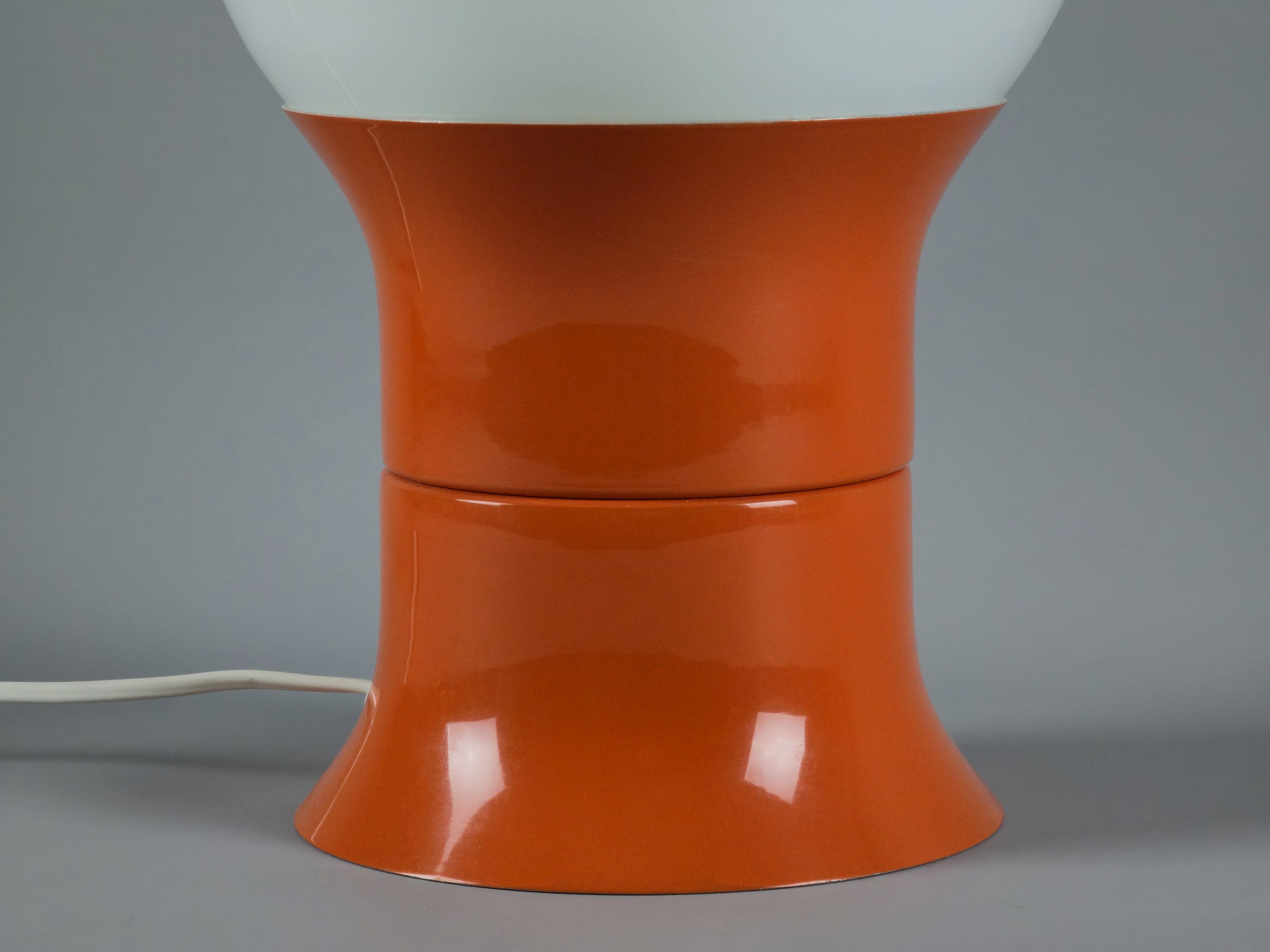 1971 Space age design 'HEMI Klot 2' table lamp by Lennart Centervall, with opaline glass ball shade and orange lacquered base, detailed image of the orange metal base, showing the smooth texture of the base.