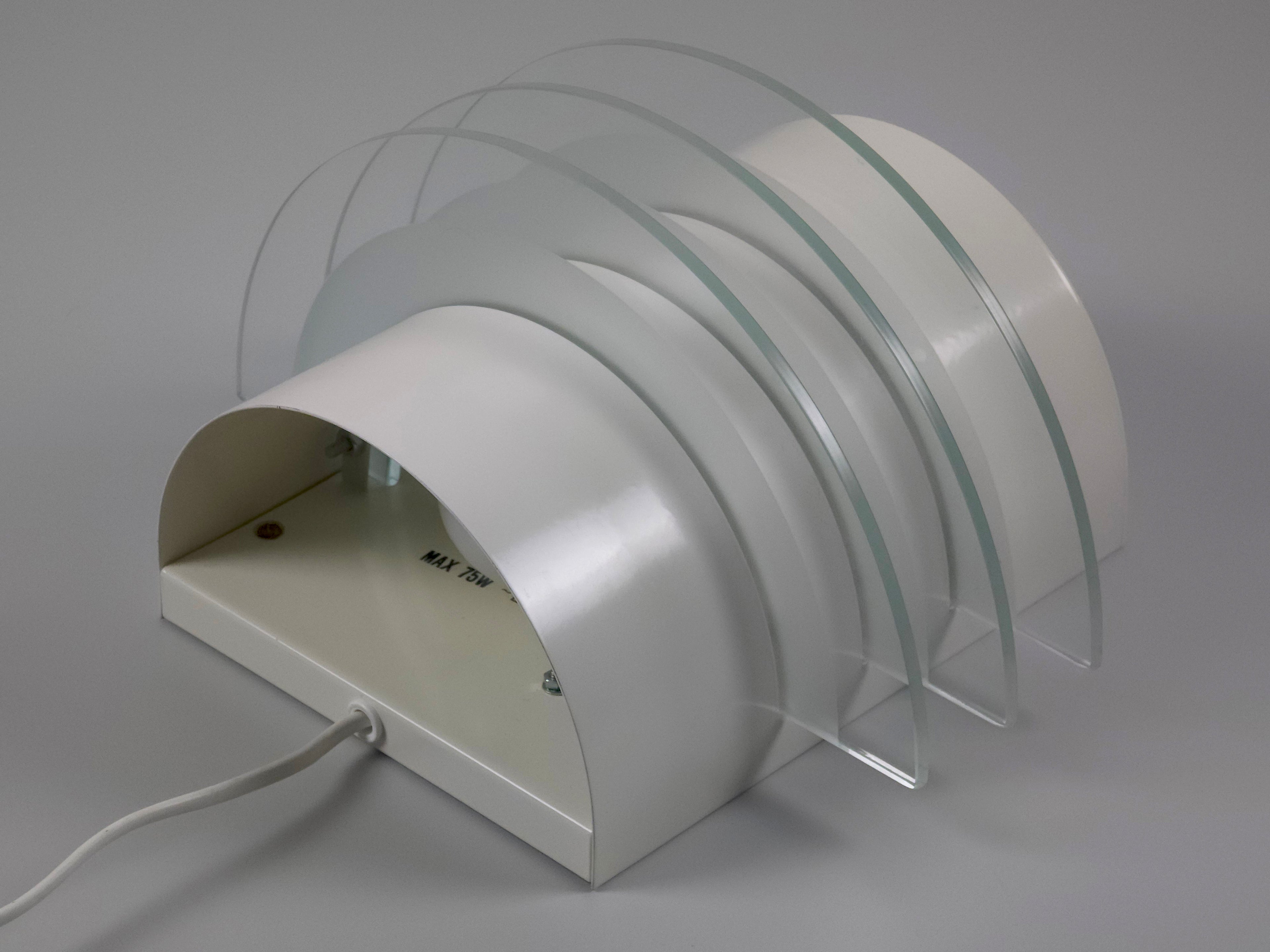 Underside view of the Drittel sconce illustrating the semicircular wall mount and light-filtering glass tiers.