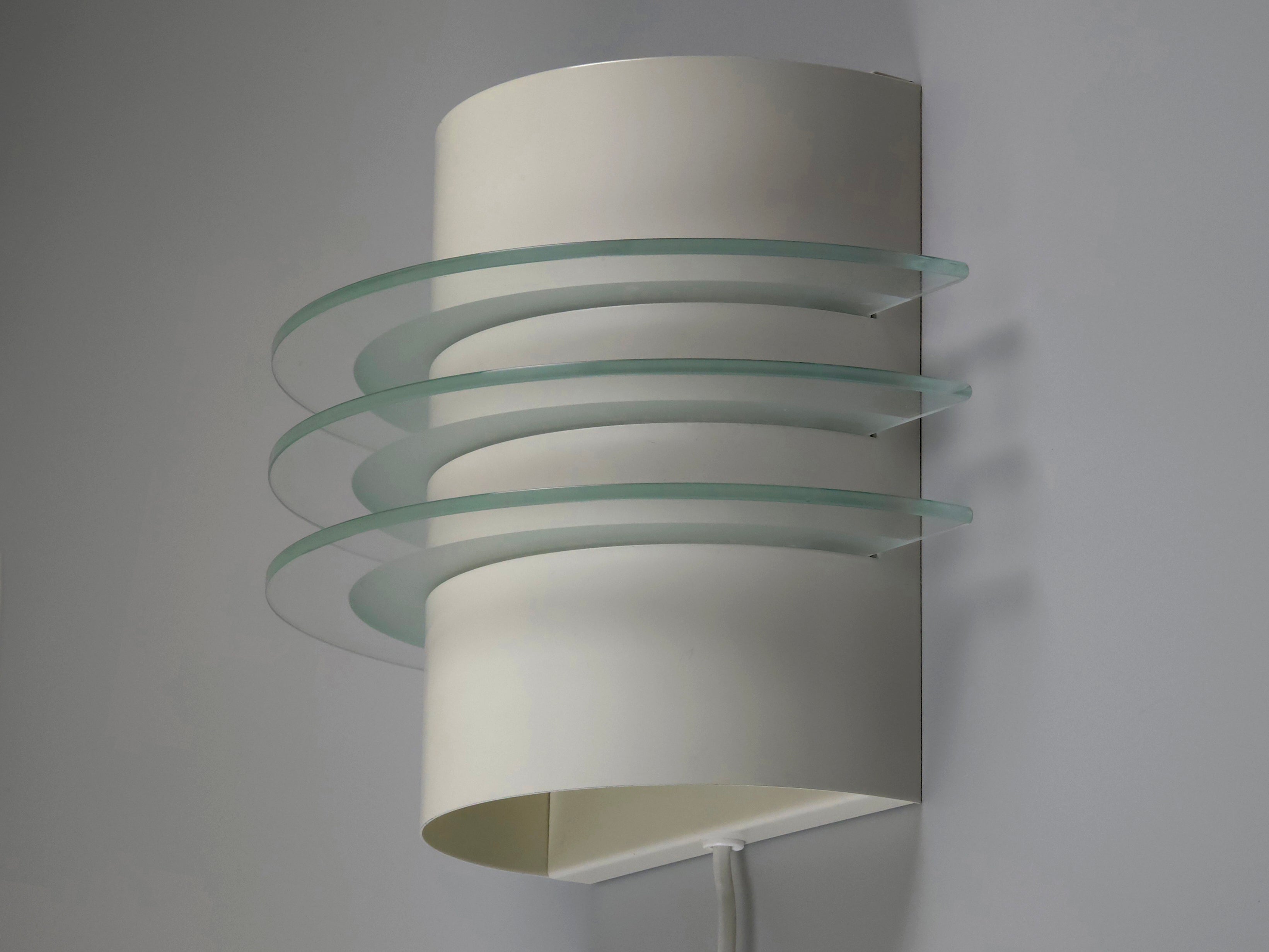 Side view of IKEA Drittel wall sconce showing the tiered postmodern glass discs and sleek curved white metal body.