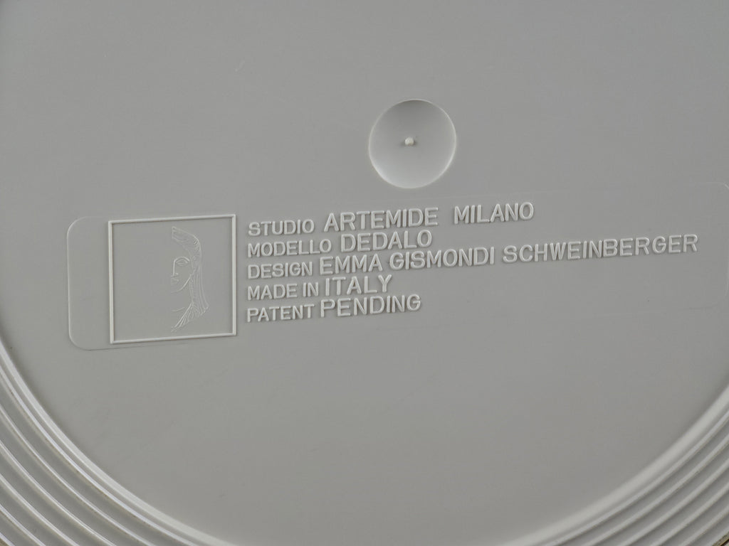 Close-up of the manufacturer's mark 'Artemide Milano Made in Italy' on the plastic base.