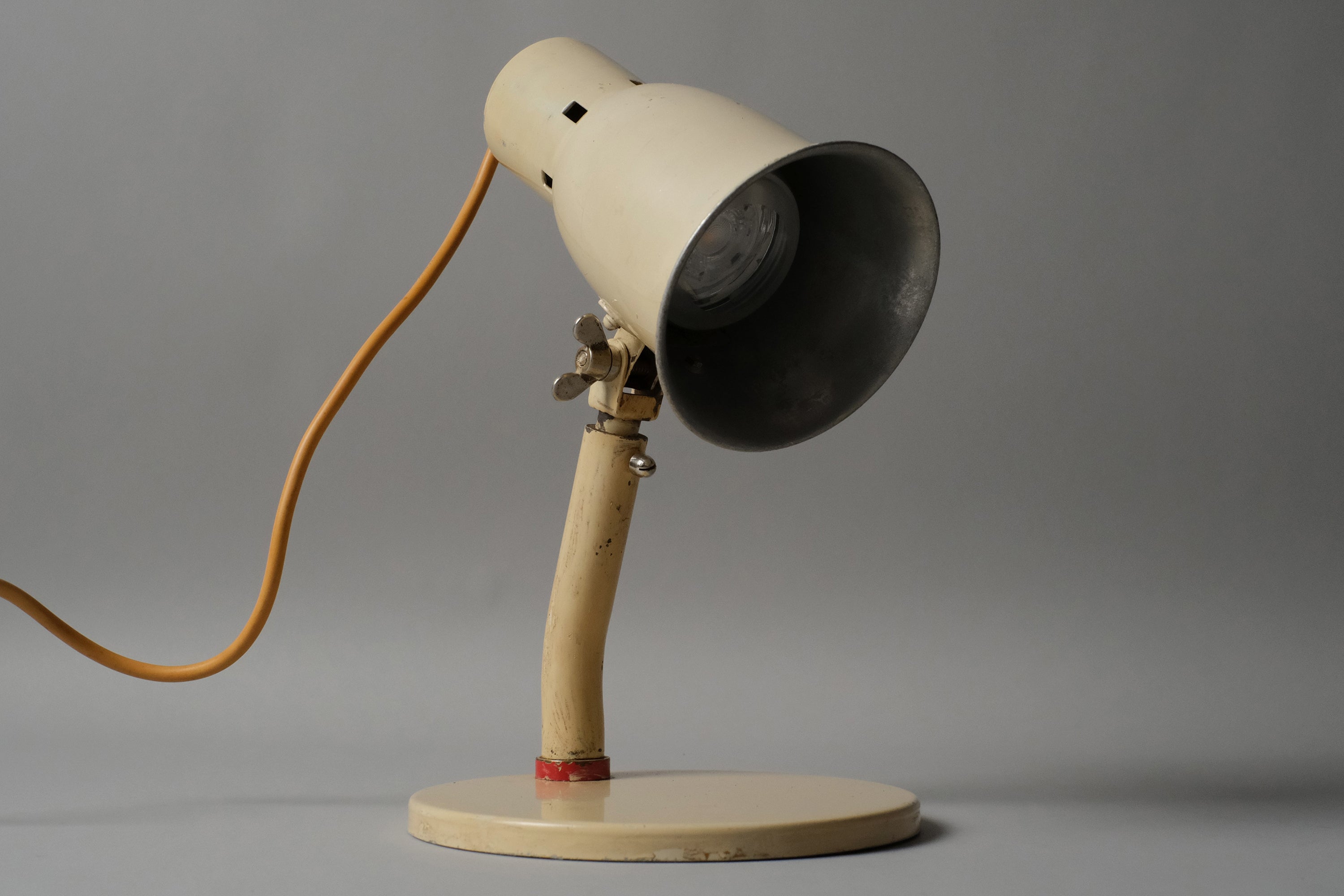 Angled front view of a cream enamel Bauhaus desk lamp, Kandem type, 1920s-1930s Germany, showing the full articulated form from neck joint to shade opening.