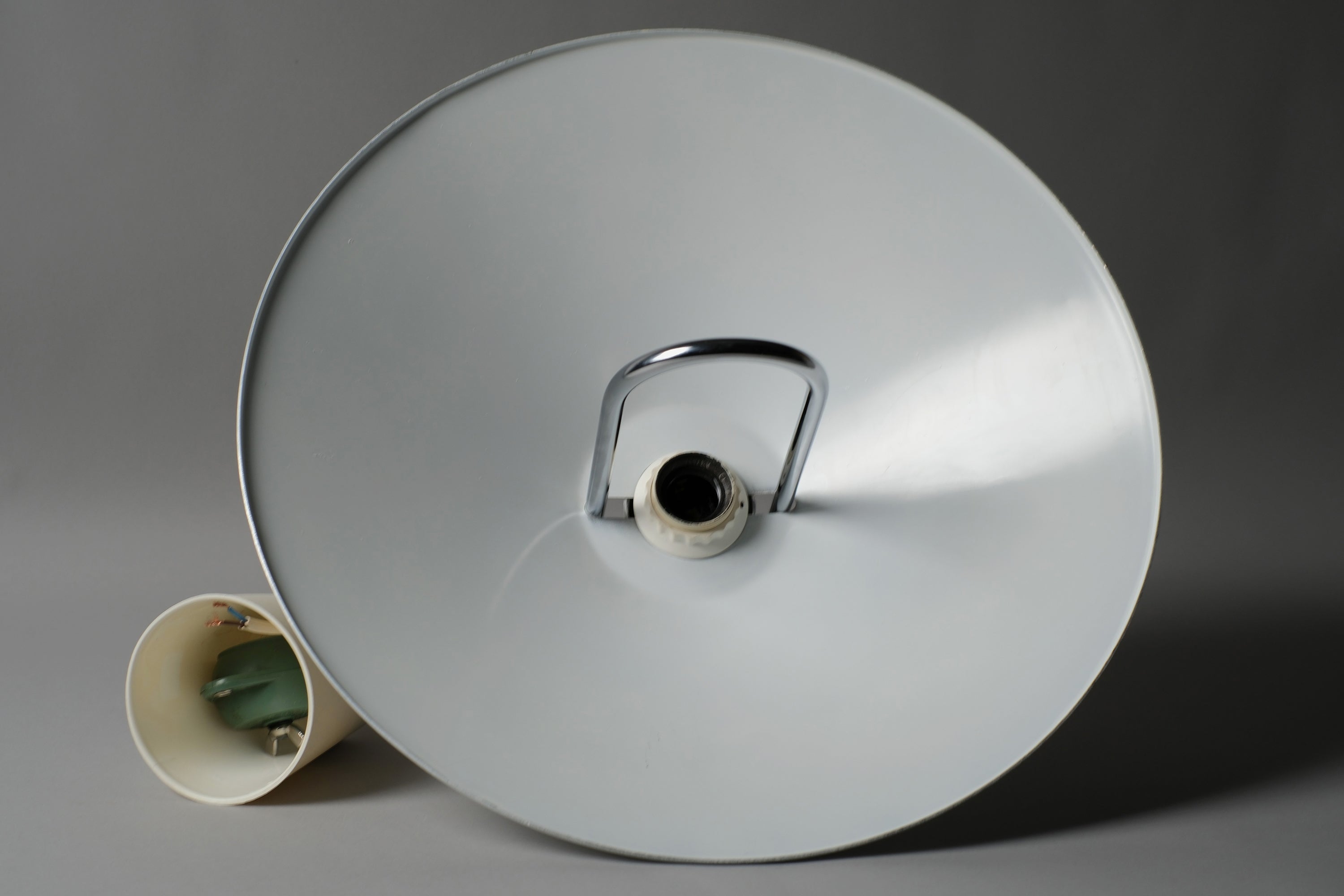 Interior view of a 1980s Belid T127 pendant lamp showing the original E27 fitting, white enamel inner shade surface, and rise-and-fall rolly mechanism hardware, Varberg Sweden.