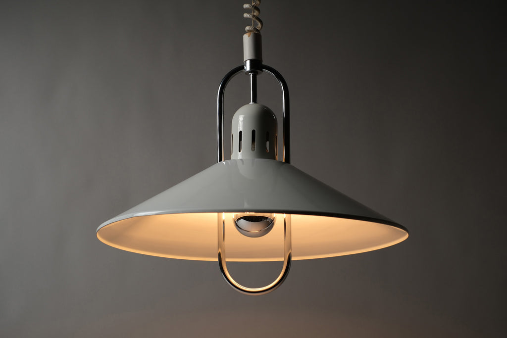 Front illuminated view of a 1980s Belid T127 pendant lamp by Jan Eskil Eskilsson for Belid Sweden, showing warm directional downlight cast from the white saucer shade with glare-free diffusion.