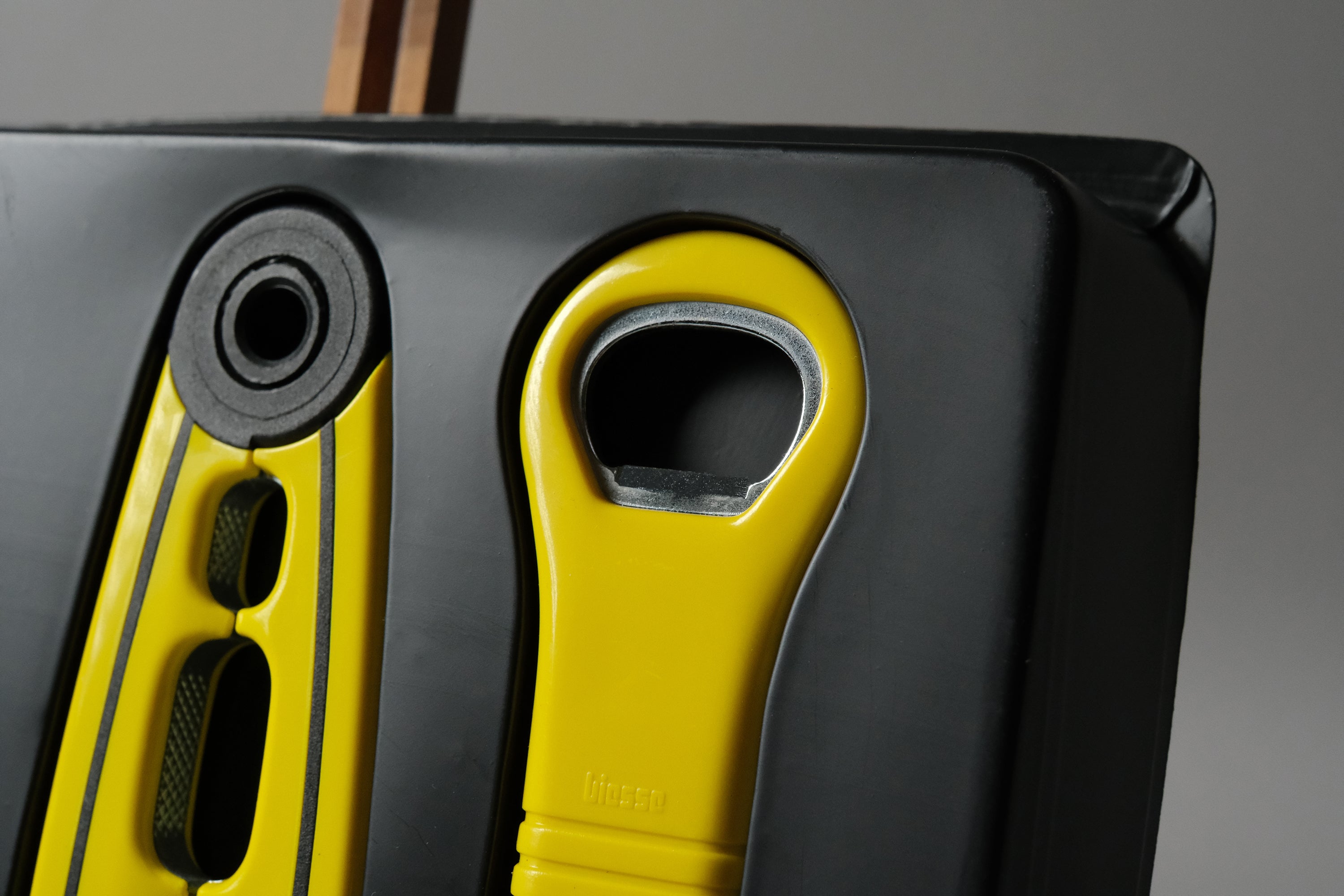 Close-up detail of the unused yellow and black Biesse bottle opener by Pino Spagnolo, original surface finish intact