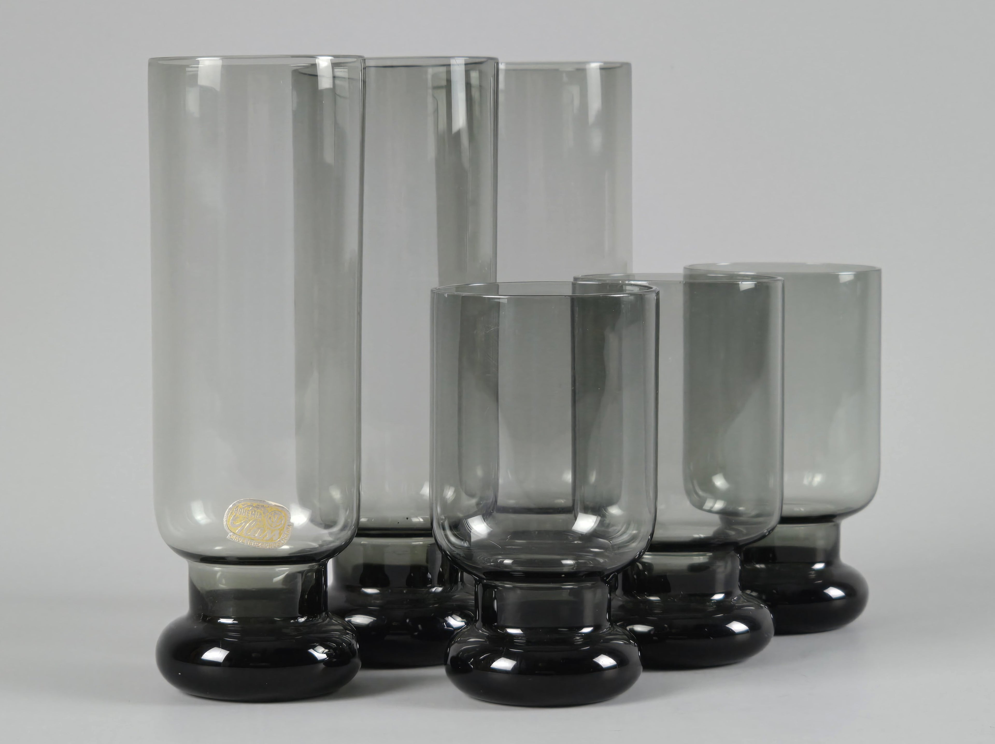 Front view of the Czechoslovakian glass set, highlighting the weighted bulbous bases and moody smoke-grey tint.