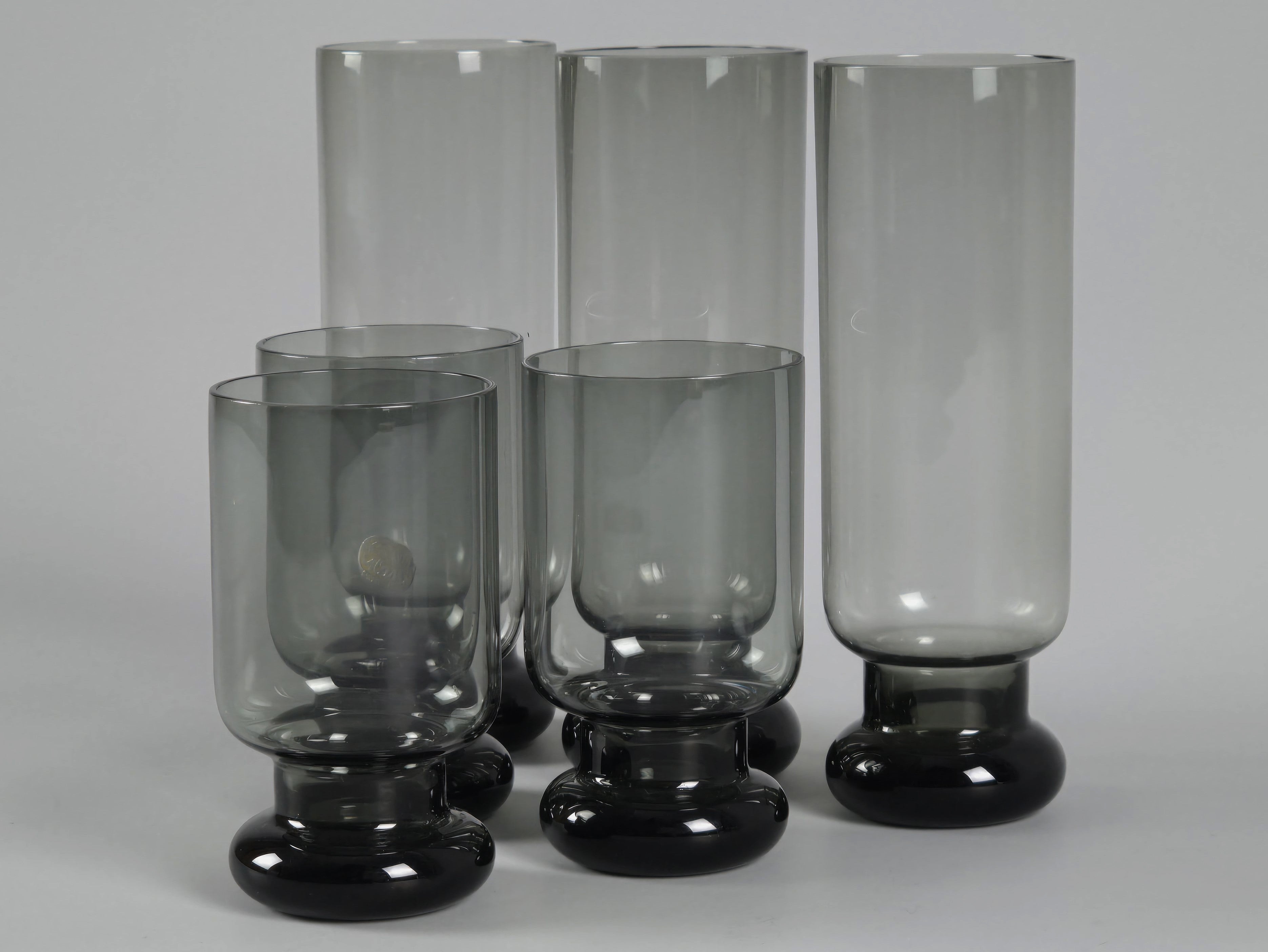 Front view of the Czechoslovakian glass set, highlighting the weighted bulbous bases and moody smoke-grey tint.