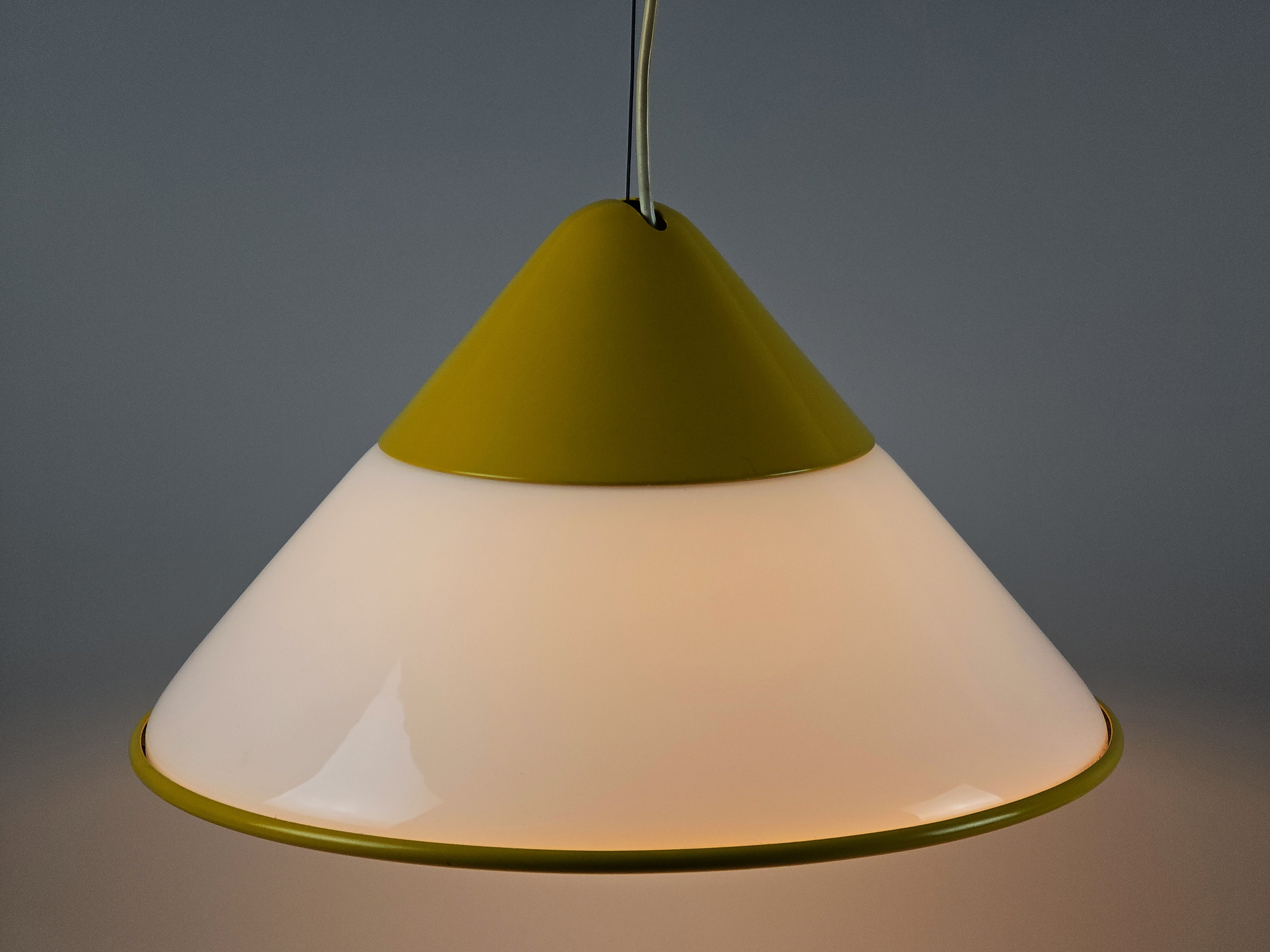 1980s Vintage Fabbian Italian opaline glass pendant lamp, Mid-Century Modern conical white opal hand-blown glass with yellow design details, soft glow lit view slightly from top.