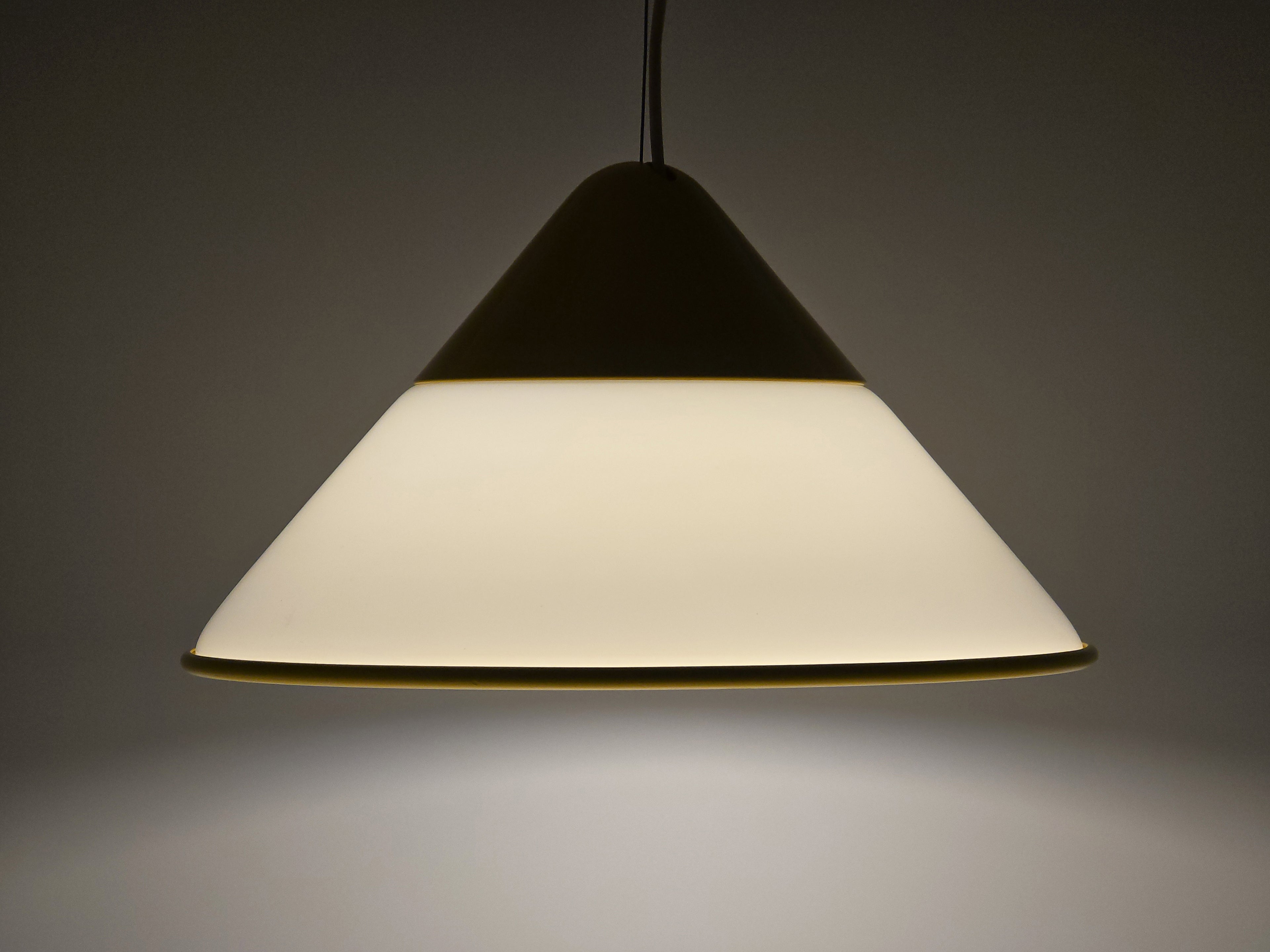1980s Vintage Fabbian Italian opaline glass pendant lamp, Mid-Century Modern conical white opal hand-blown glass with yellow design details, showing lit full conical profile view.