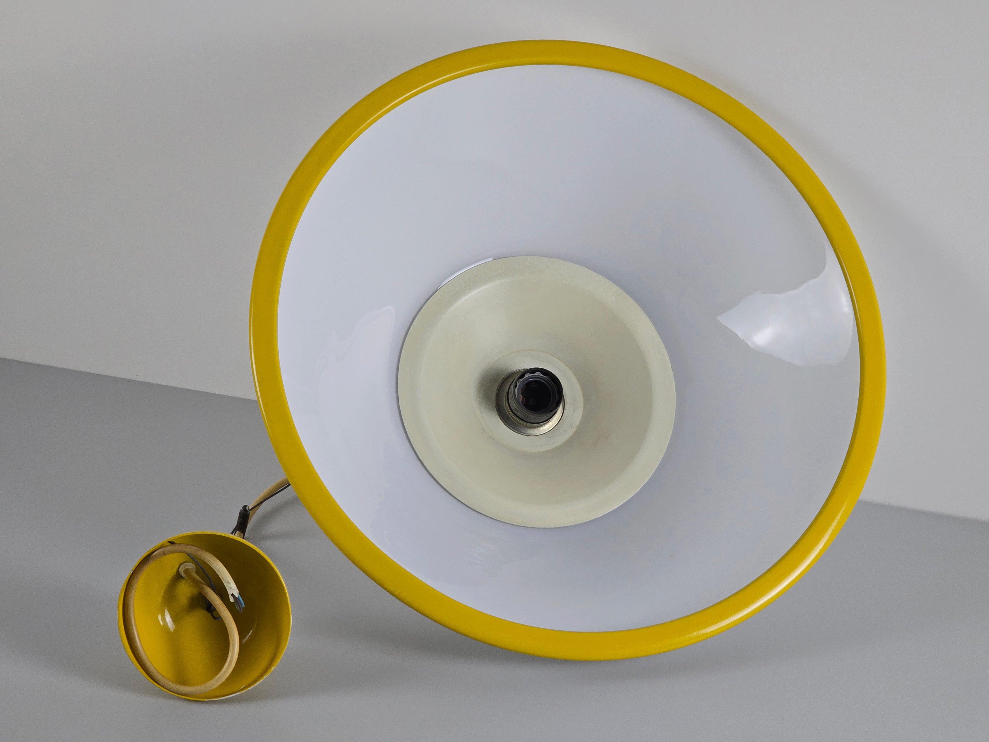 1980s Vintage Fabbian Italian opaline glass pendant lamp, Mid-Century Modern conical white opal hand-blown glass with yellow design details, showing the full view of the inner side of the glass shade and light bulb fitting.
