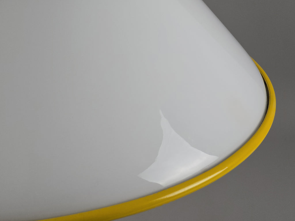 1980s Vintage Fabbian Italian opaline glass pendant lamp, Mid-Century Modern conical white opal hand-blown glass with yellow design details, showing the yellow metal border on the underside of the lamp.