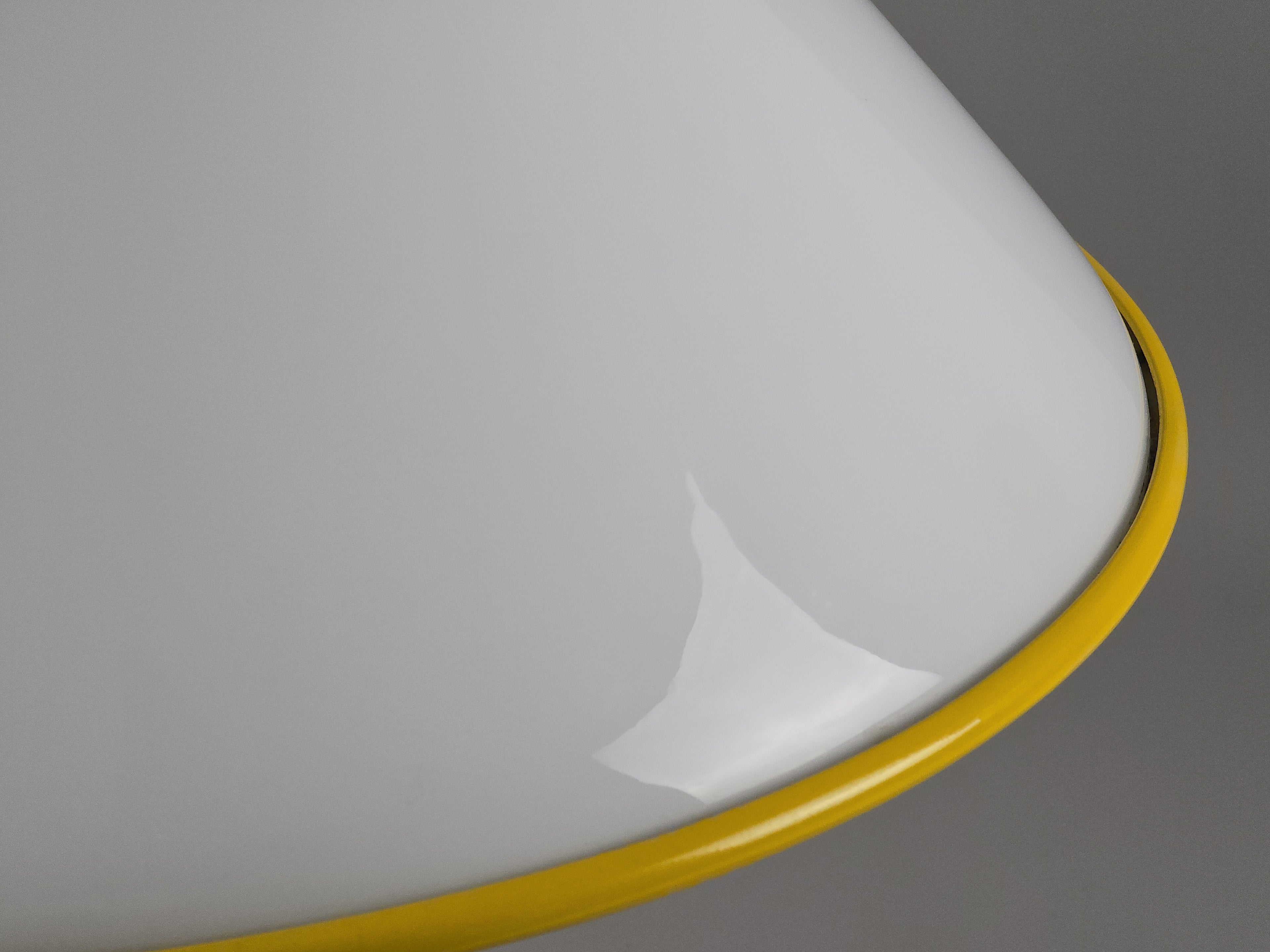 1980s Vintage Fabbian Italian opaline glass pendant lamp, Mid-Century Modern conical white opal hand-blown glass with yellow design details, showing the yellow metal border on the underside of the lamp.