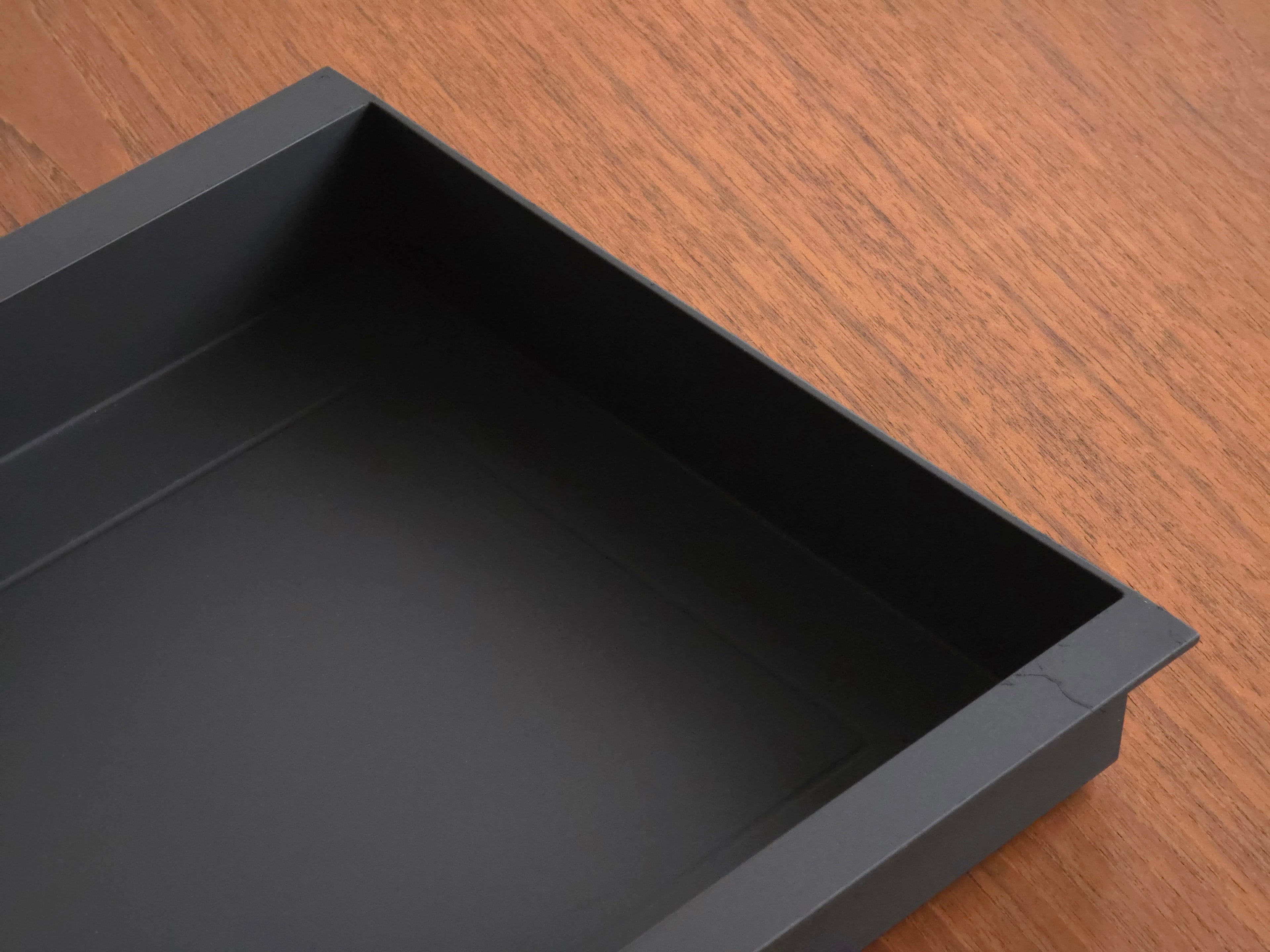 Vintage Helit document tray designed by Norman Foster, matte black soft-touch finish, close up photo of the back side showing the straight line design.