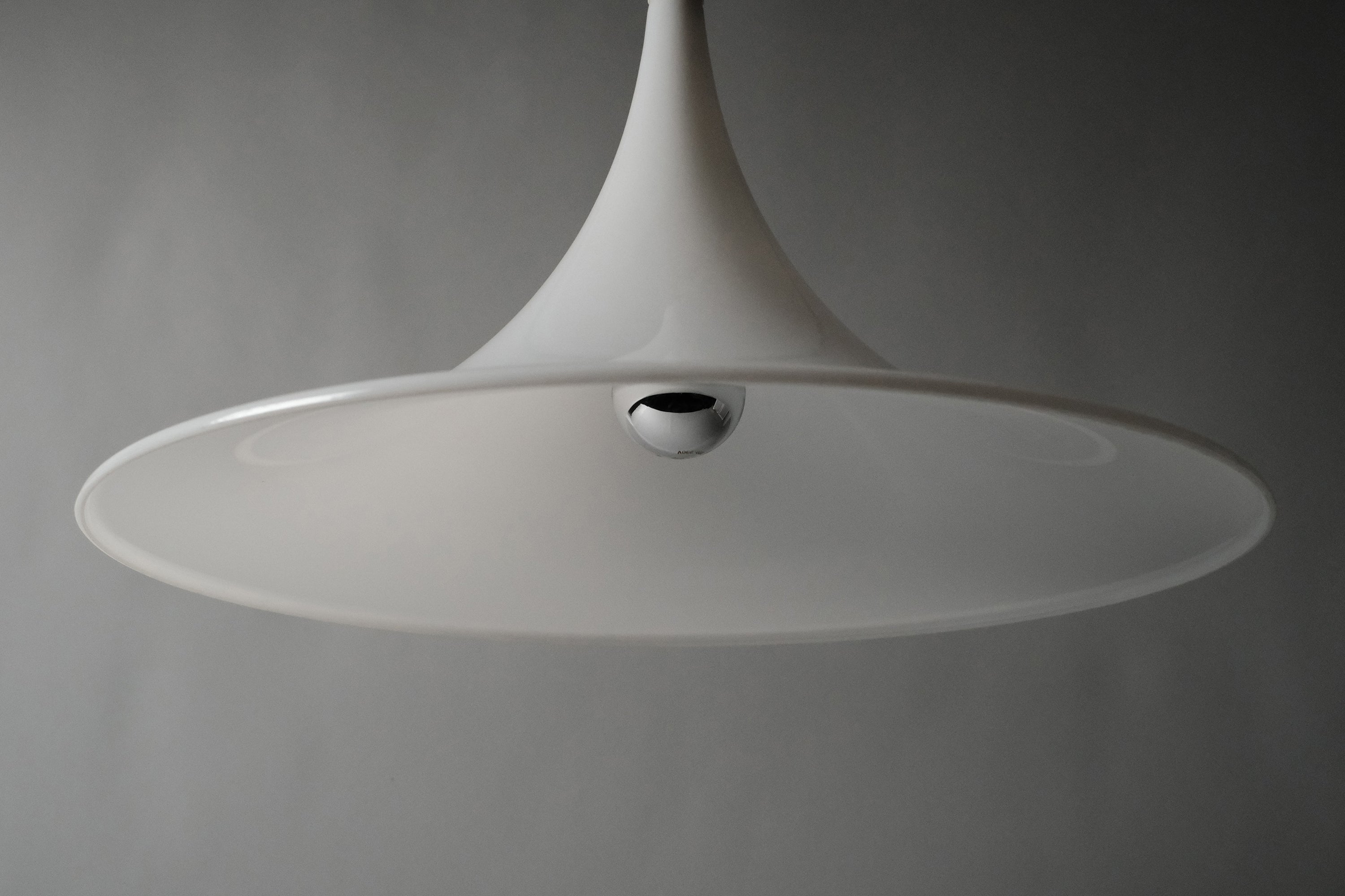 Low angle front view of the Dijkstra witch hat pendant, emphasising the dramatic swept conical form and opaline translucency