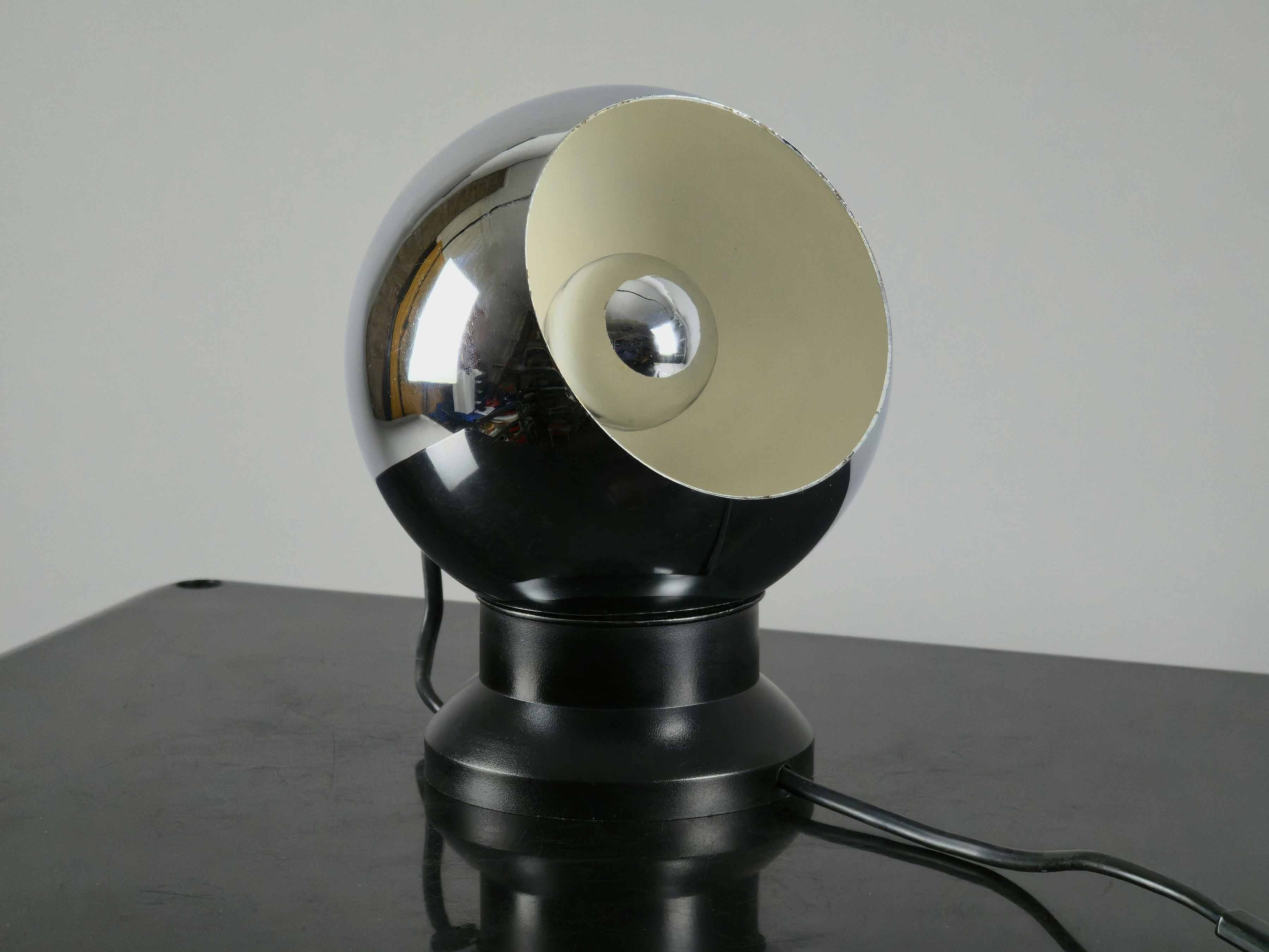 E.S. Horn magnetic ball lamp angled showing it's space-age form set on a black table and a neutral background.