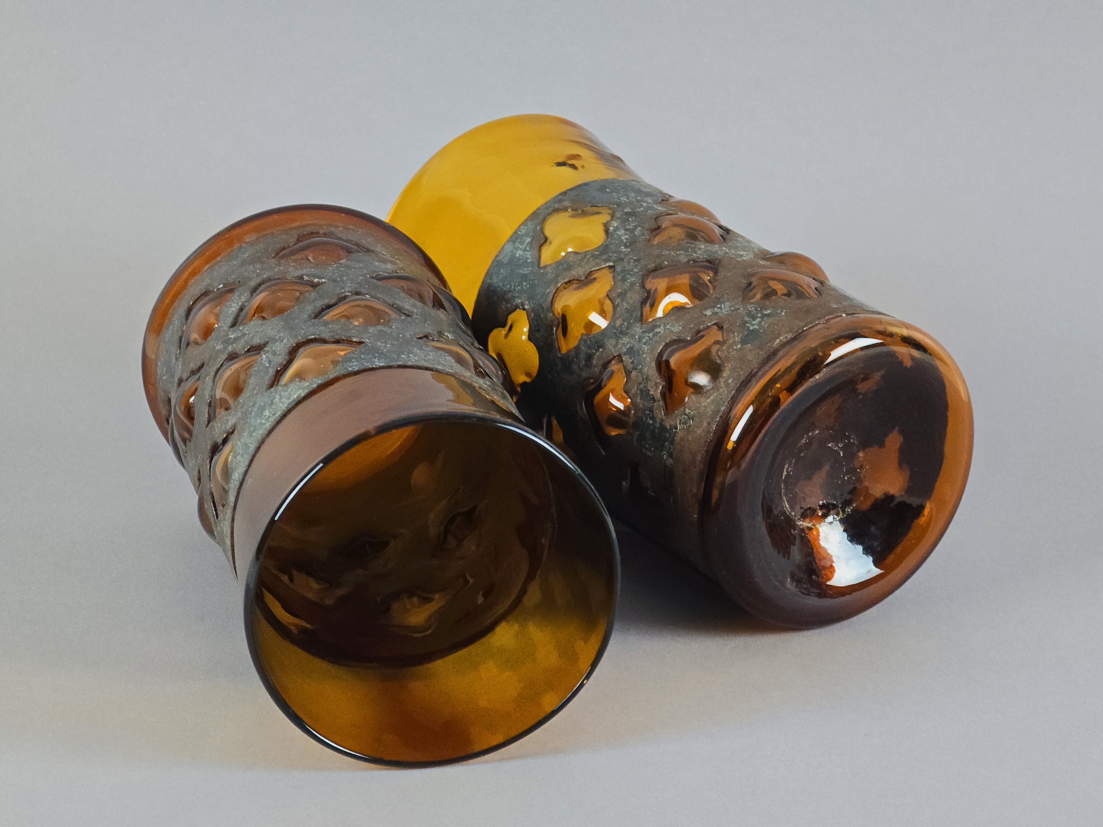 Two Mexican modernist tumblers laid on their side, showing the handmade variation in the glass.