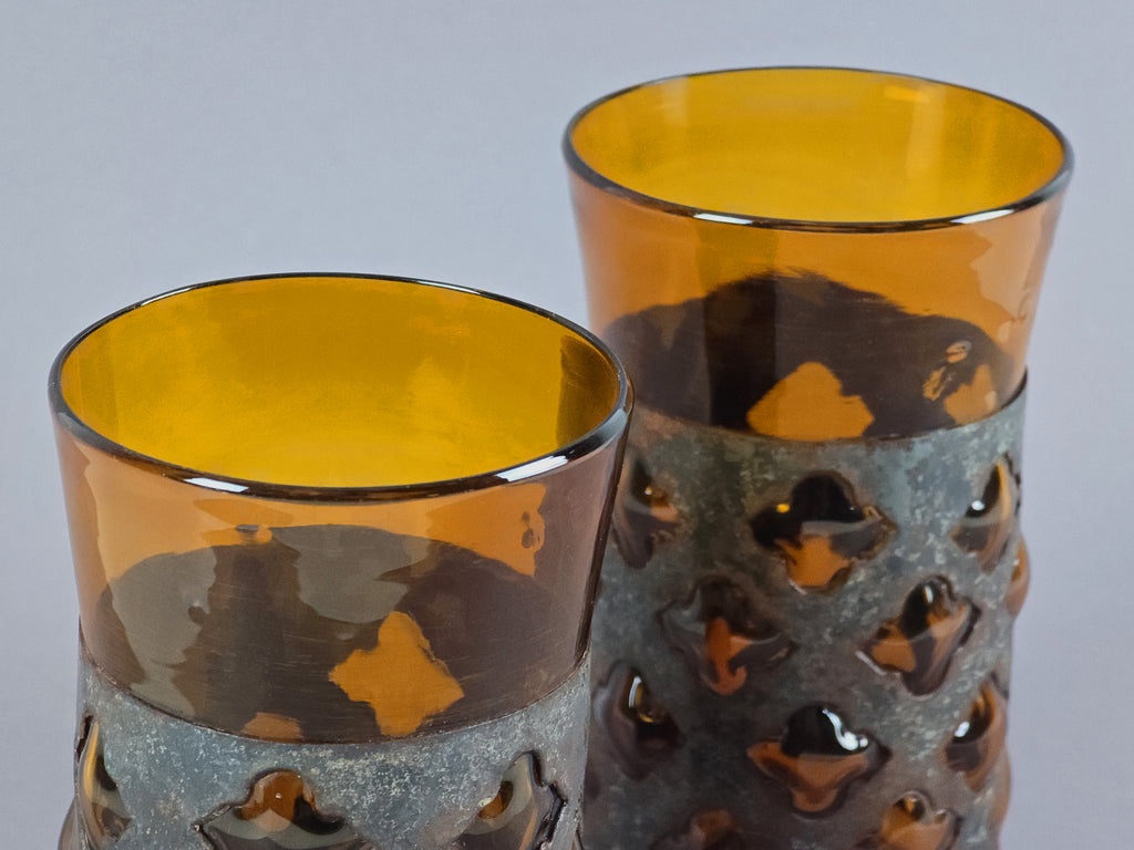 Top-down view into the amber glass tumblers, showing the smooth interior and rich color.