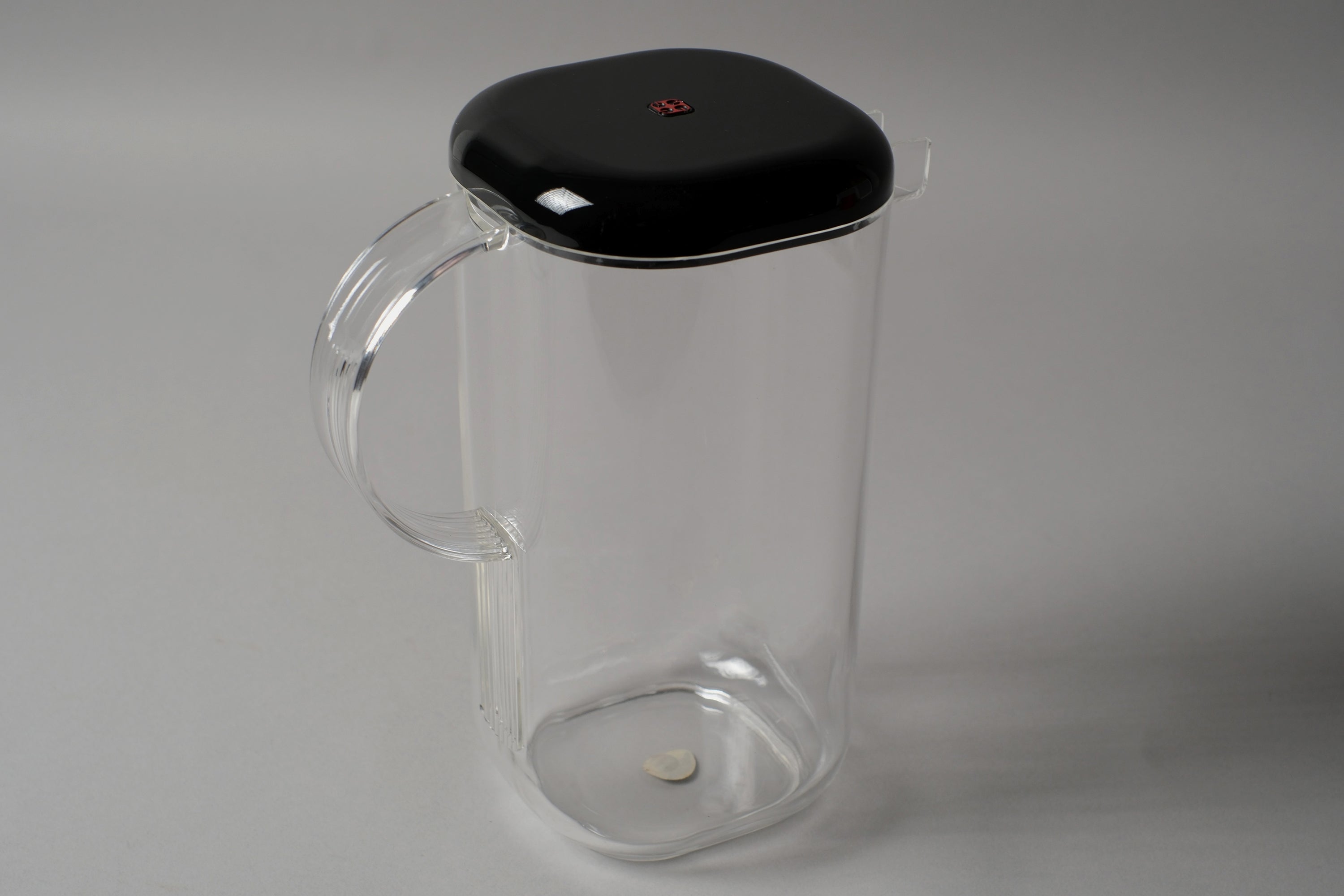 Guzzini Amanda pitcher by Ambrogio Pozzi, clear acrylic with black lid, showing handle and lid detail, Italy 1970s