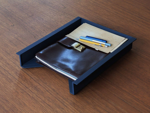 Vintage Helit document tray designed by Norman Foster, matte black soft-touch finish, shown with office accessories for scale, minimalist architectural desk organizer.