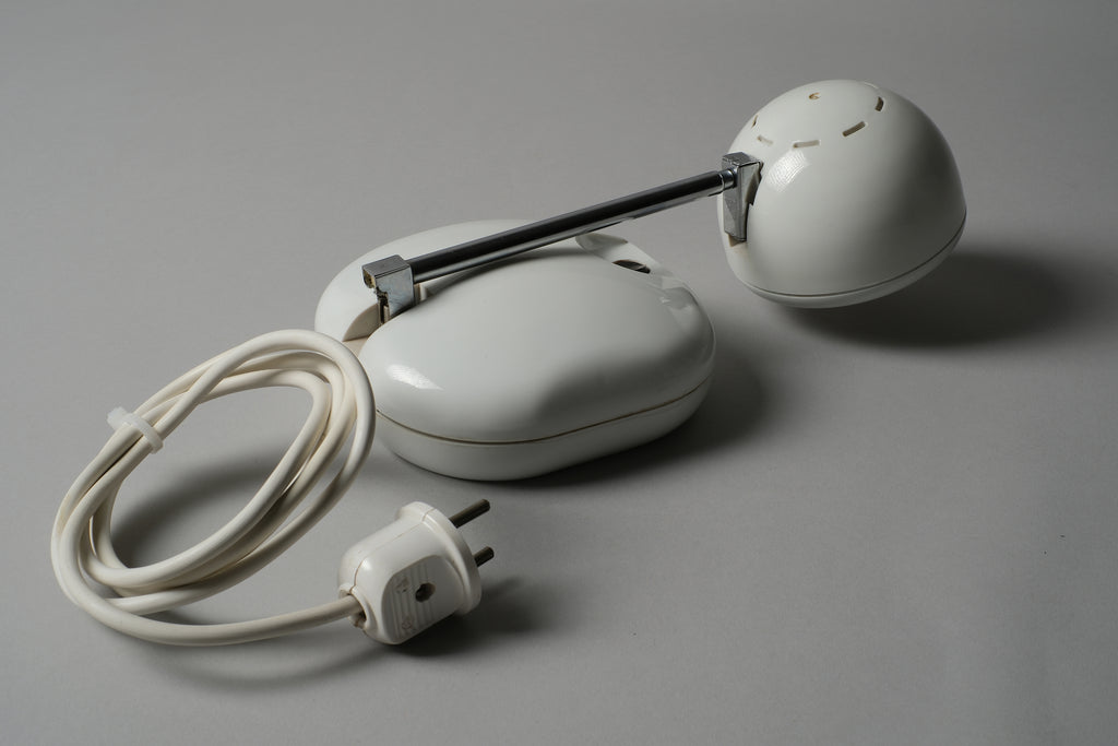 Compact view of a 1970s Hustadt Leuchten antenna halogen desk lamp from West Germany with the telescopic stem fully collapsed, showing the oval base, original cord and power plug.