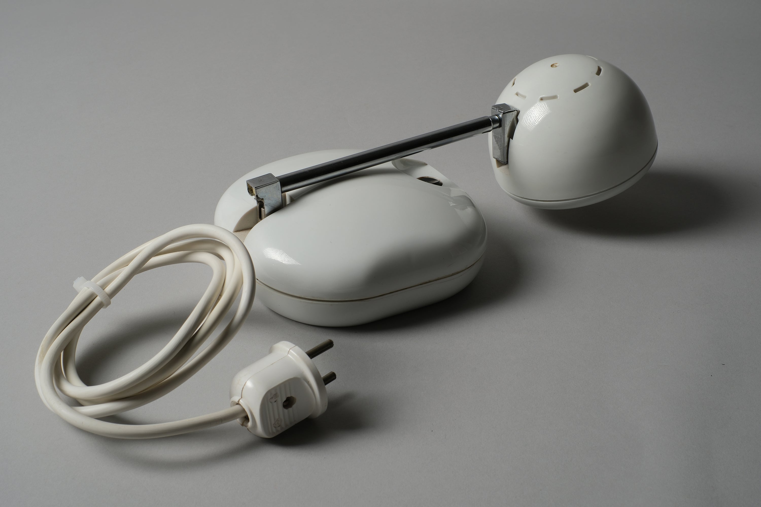 Compact view of a 1970s Hustadt Leuchten antenna halogen desk lamp from West Germany with the telescopic stem fully collapsed, showing the oval base, original cord and power plug.