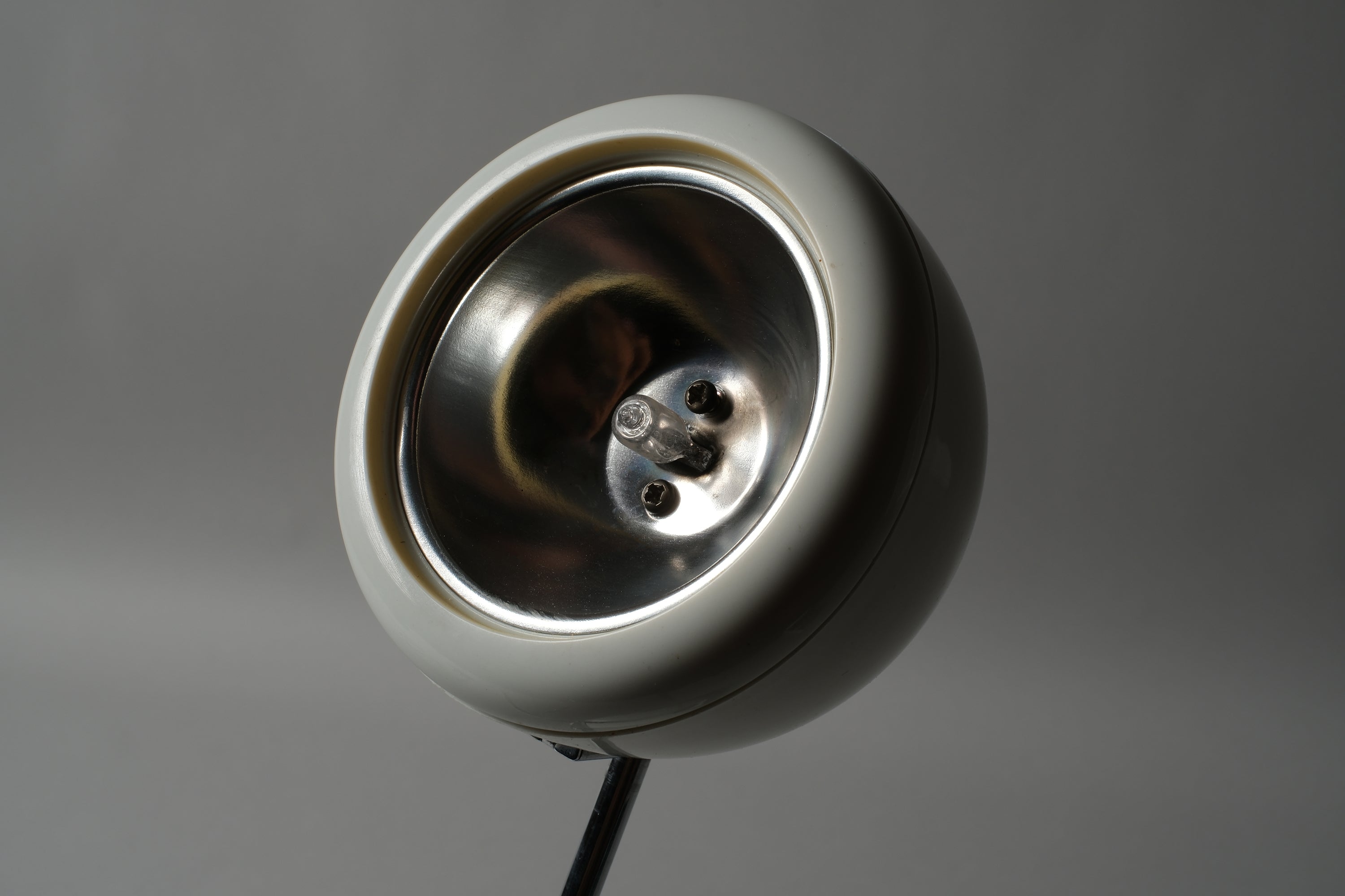 Interior macro detail of the spherical halogen spot head of a 1970s Hustadt Leuchten antenna desk lamp from West Germany, showing the G4 halogen fitting and reflector construction.