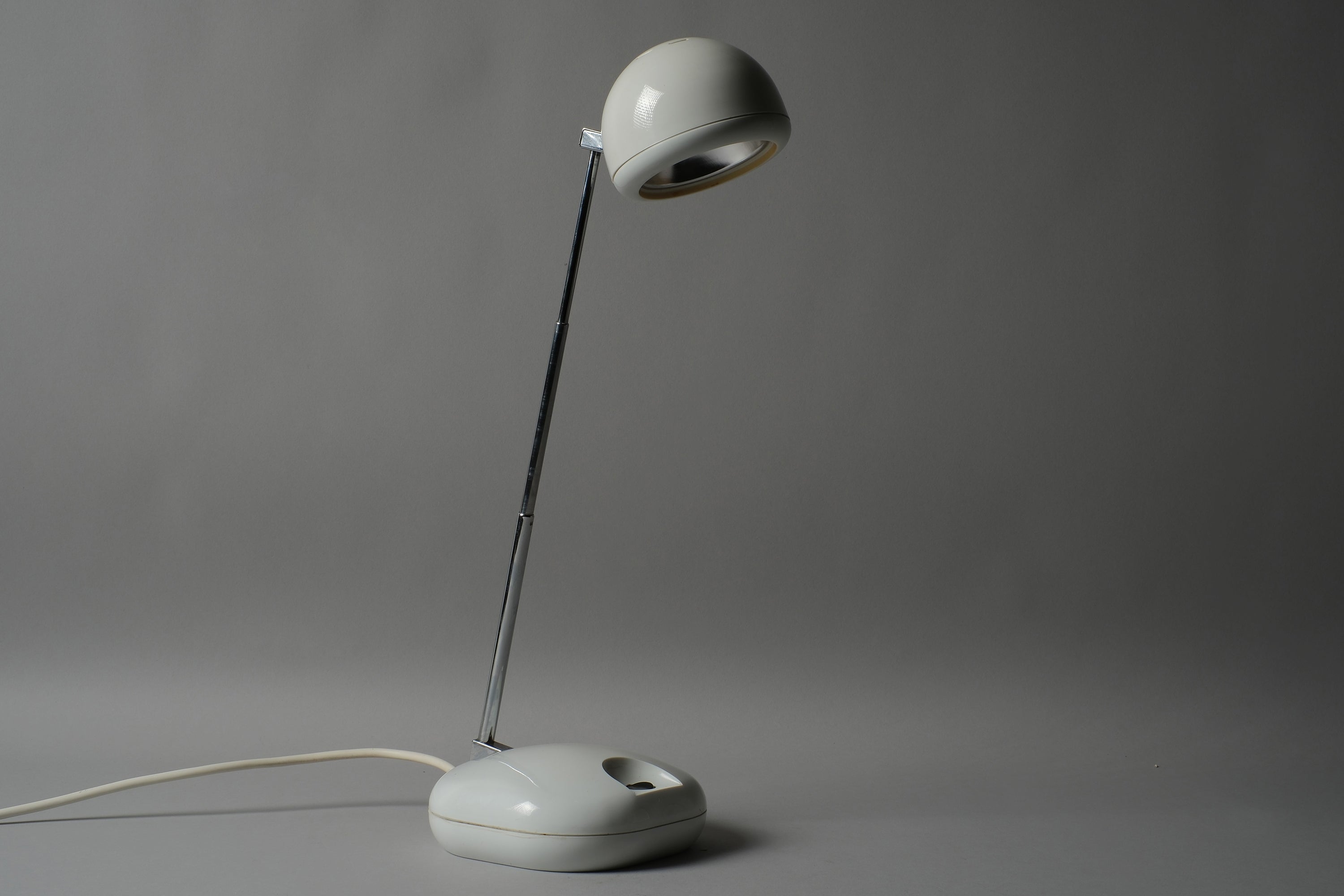 Profile view of a 1970s Hustadt Leuchten antenna halogen desk lamp from West Germany, showing the full silhouette of the extended telescopic stem, spherical head and oval base against a neutral background.