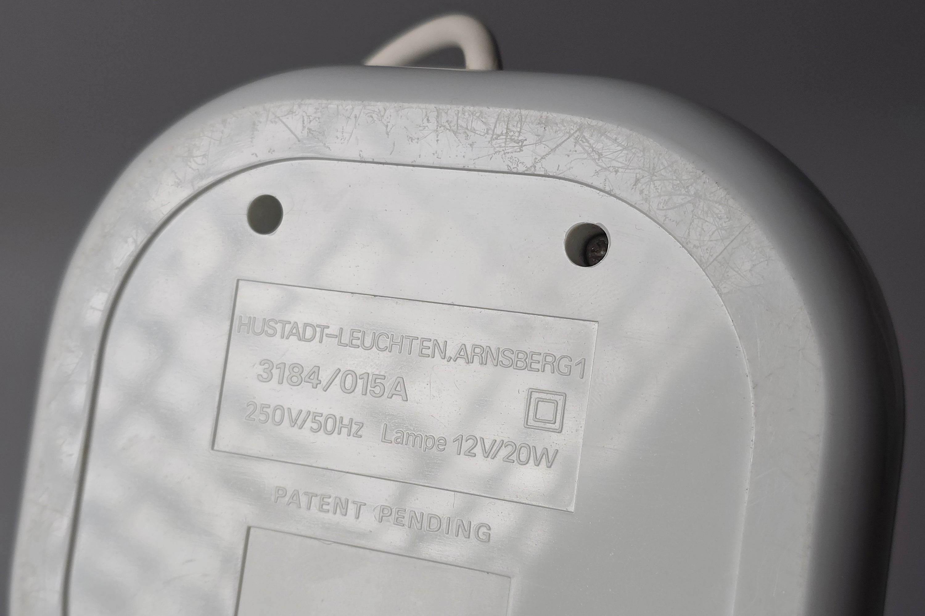 Underside of the oval base of a 1970s Hustadt Leuchten antenna halogen desk lamp from West Germany, showing the original factory stamp confirming Type 3184, 12V/20W, 250V 50Hz specifications.