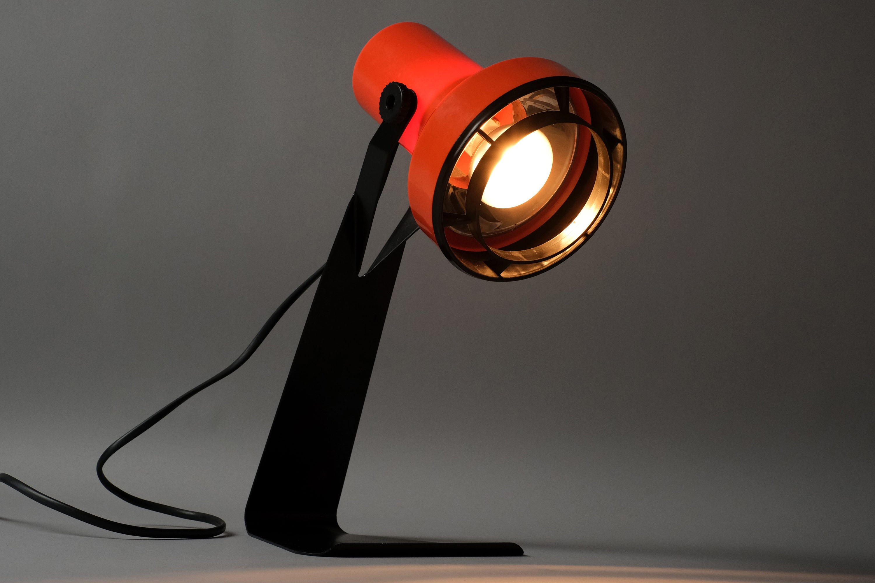 Front view of the Lyskaer Belysning Type 632 orange desk lamp fully illuminated, warm directional E14 light beam visible