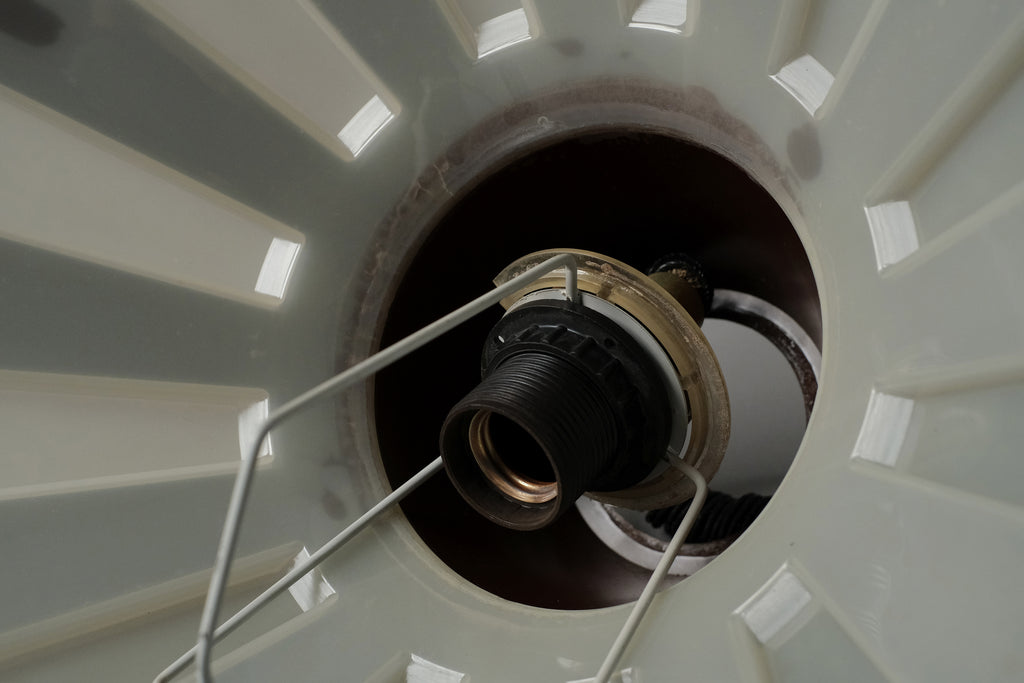 Macro detail of the original E27 fitting and rolly pull handle of a 1970s Massive Lighting Belgium UFO pendant lamp, showing the complete original hardware assembly.