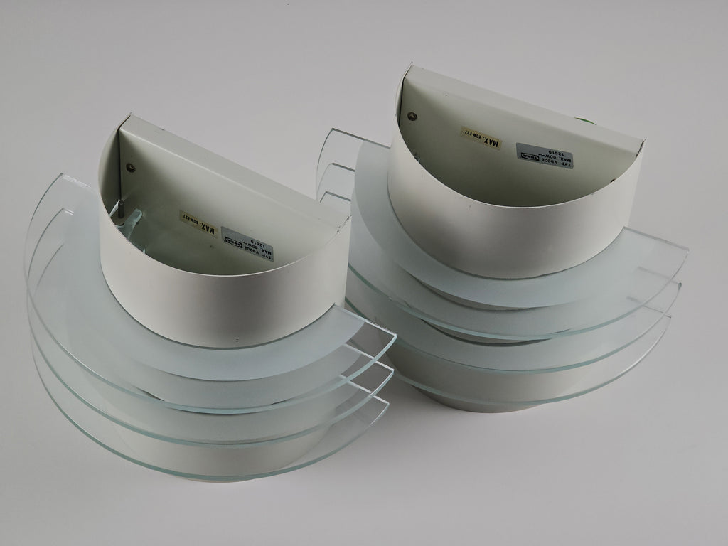 Bird's eye view of two IKEA Drittel semi-circular wall lamps with glass discs.