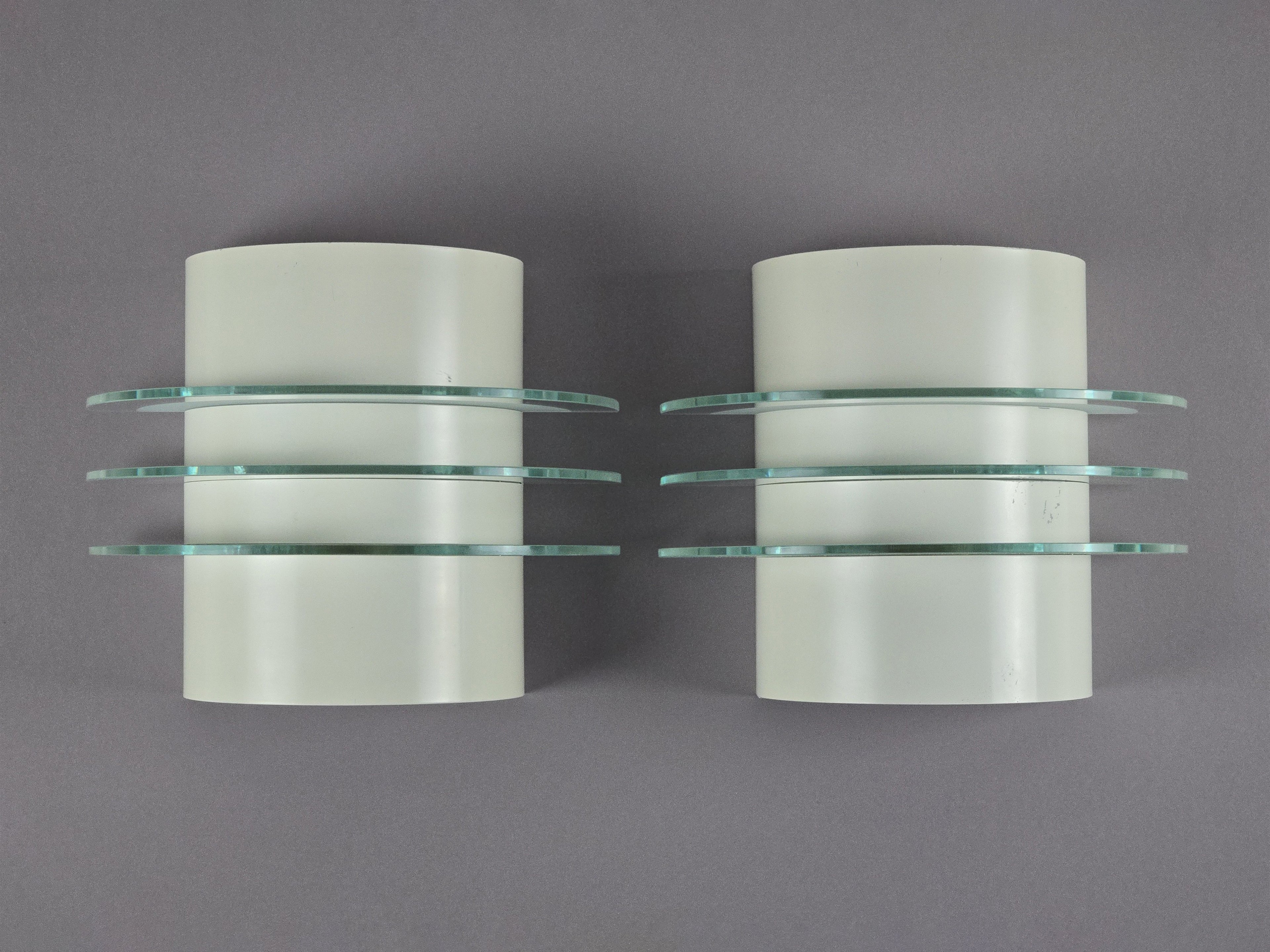 Front view of two vintage 1992 IKEA Drittel wall sconces with glass discs, wall mounted on a light grey background.