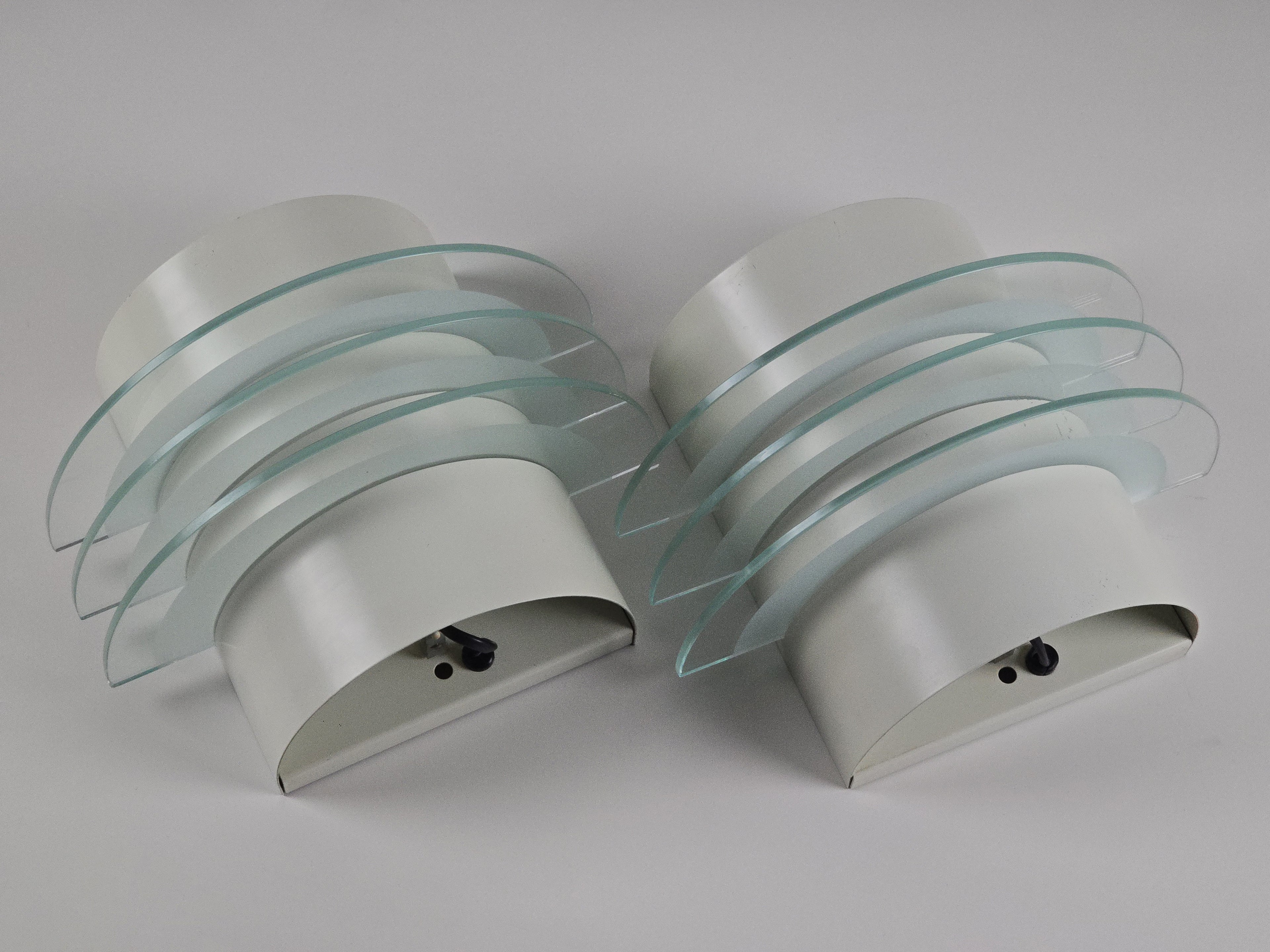 Vintage 1992 pair of IKEA Drittel wall sconces with glass discs, top down view, laid on a table with neutral background.