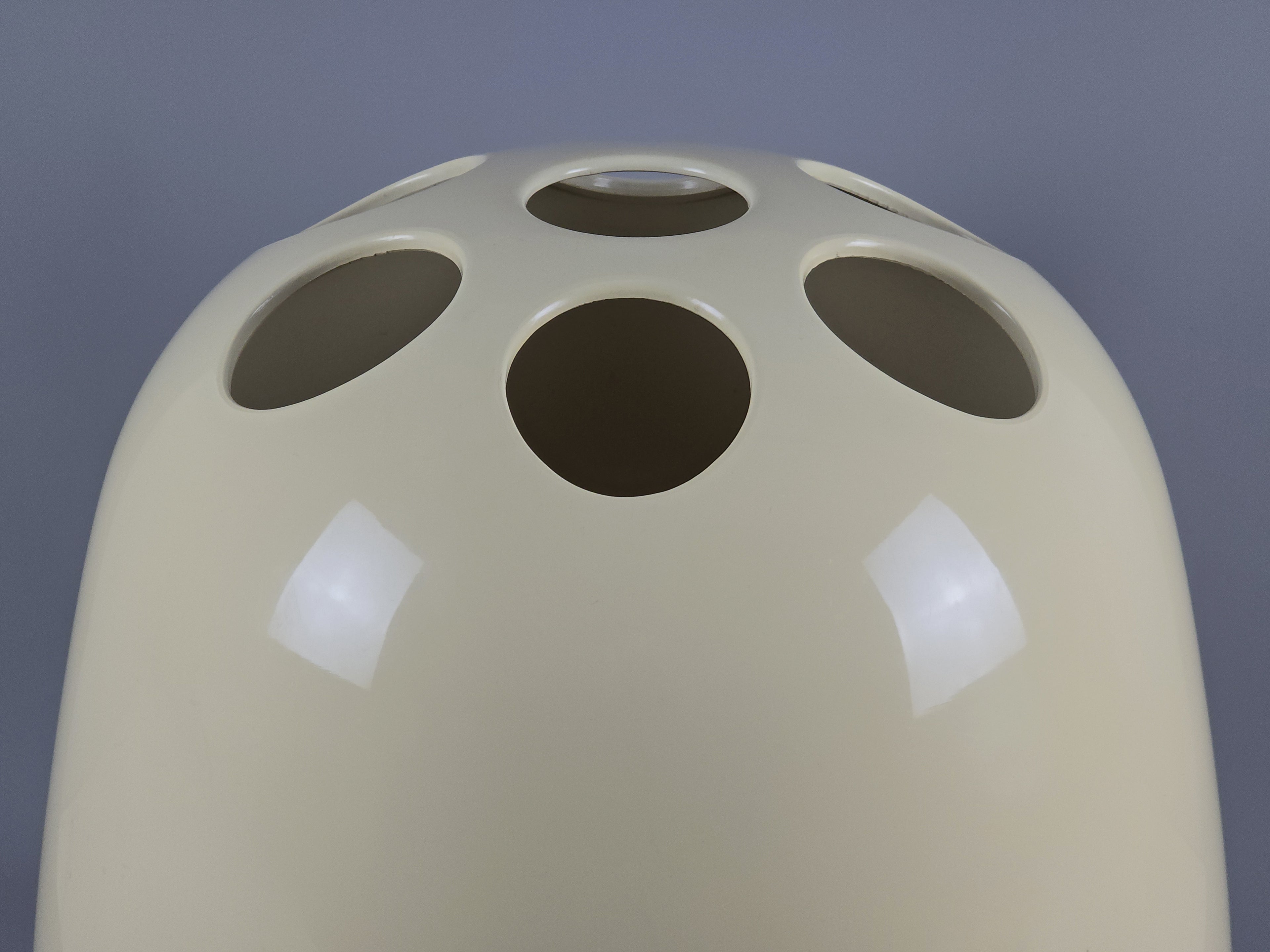 Close-up detail of the cylindrical form and circular cutouts of the Artemide Dedalo stand.