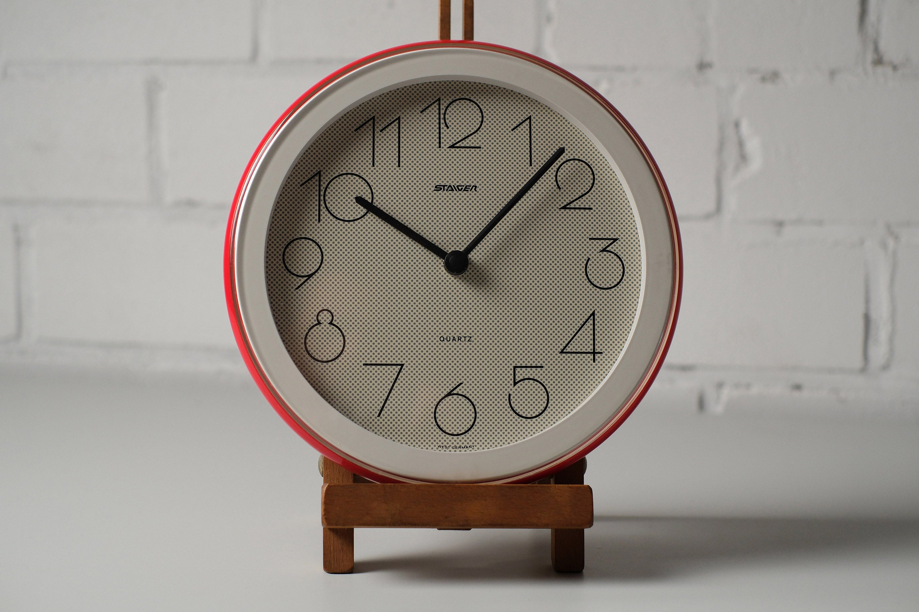 Front view of vintage 1980s postmodern round wall clock by Staiger West Germany with pop-art dotted face, red and white plastic frame.