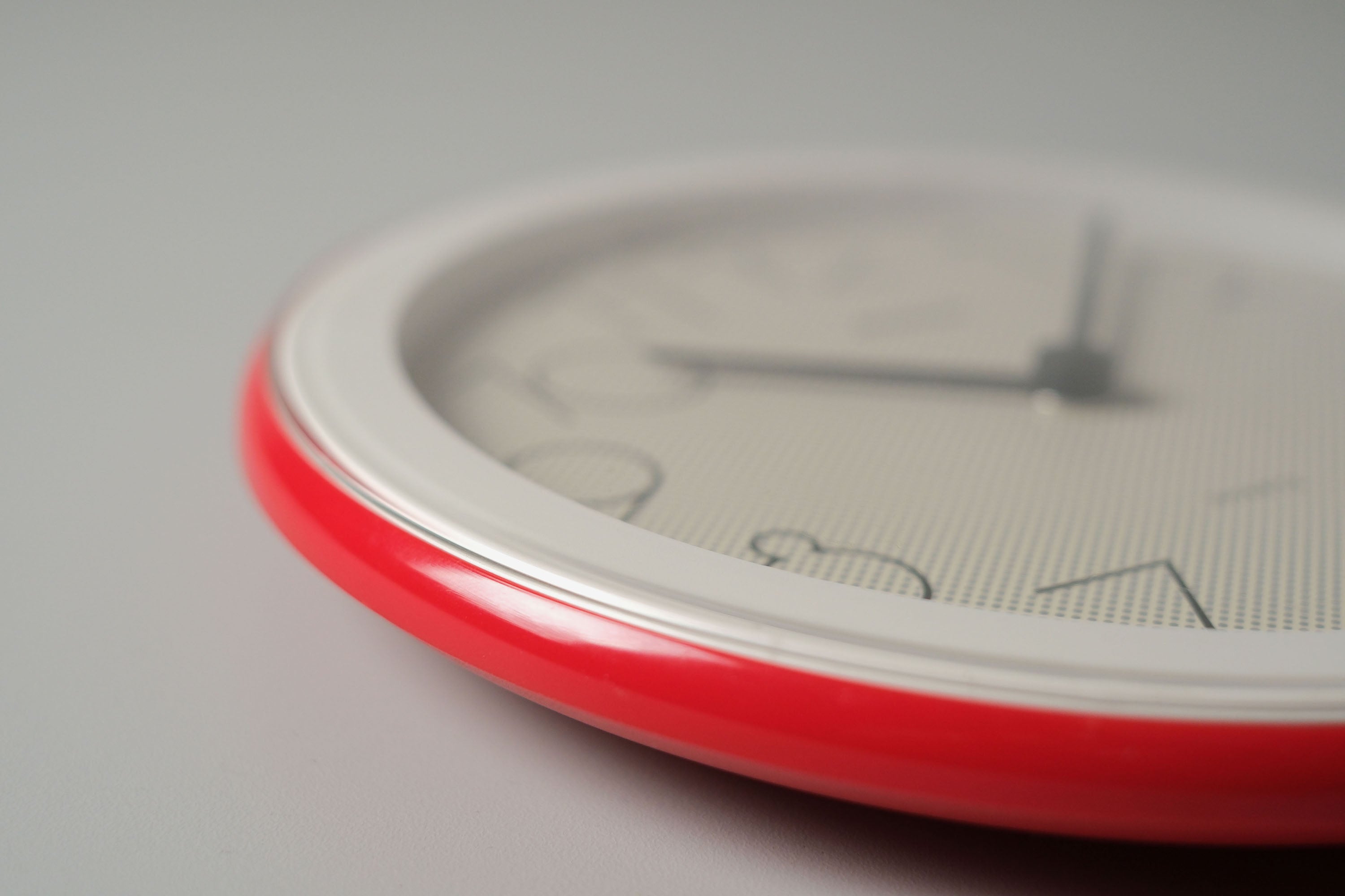 Macro shot of the red and white plastic frame, showing the excellent vintage condition of the Staiger clock.